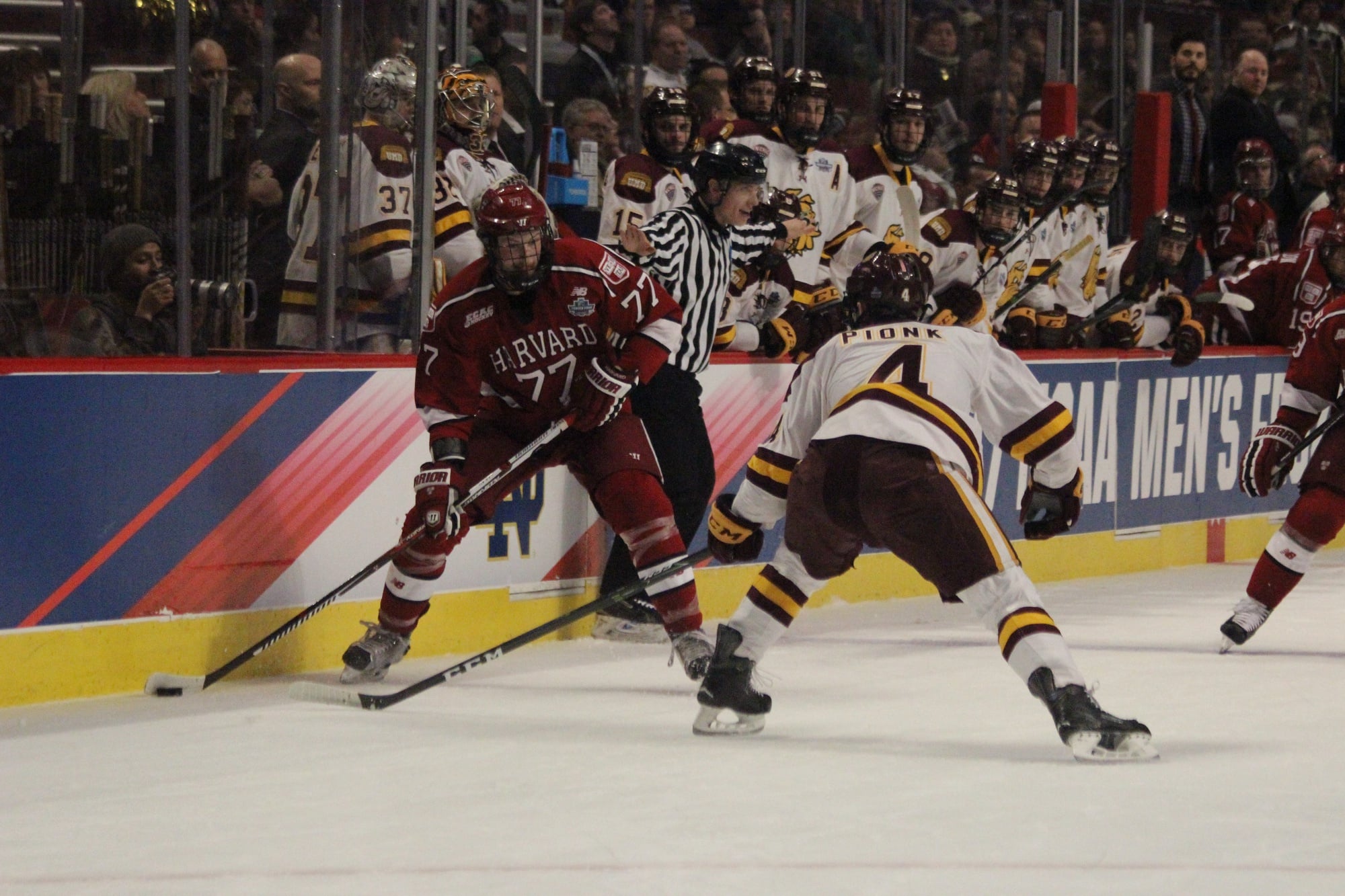 Sophomore Lewis Zerter-Gossage carries the puck during the first period of Harvard's Frozen Four bout with Minnesota-Duluth.
