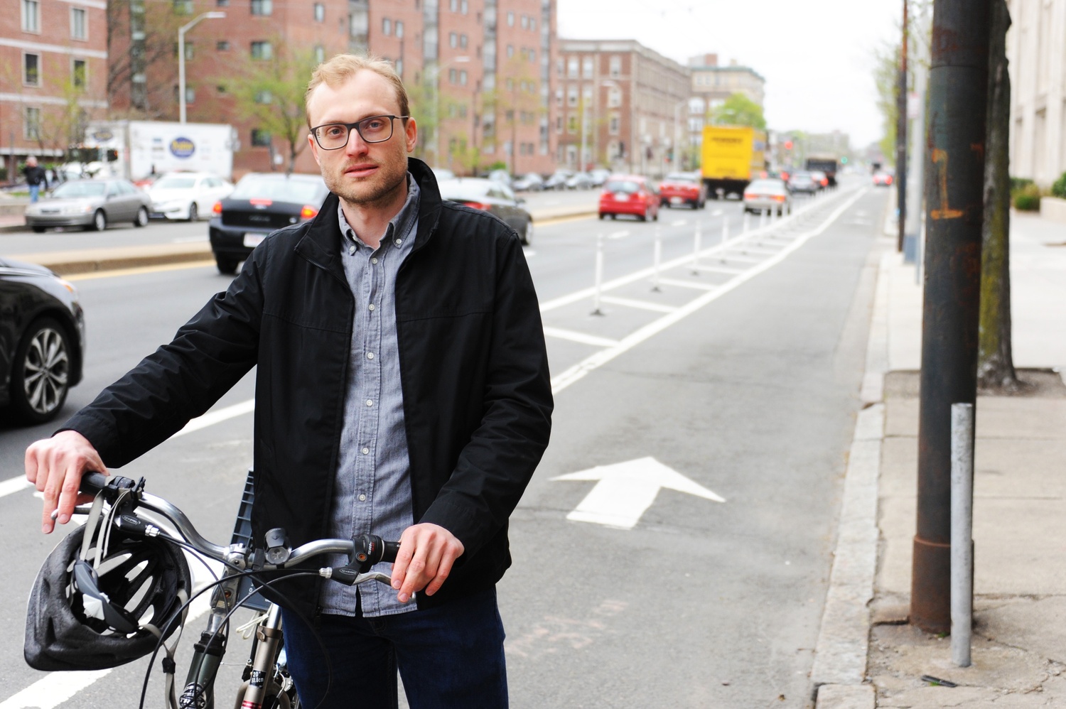 Nathanael Fillmore, a Cambridge-based bicycle activist, stands in front of a protected bike lane he advocated for on Massachusetts Ave. 
