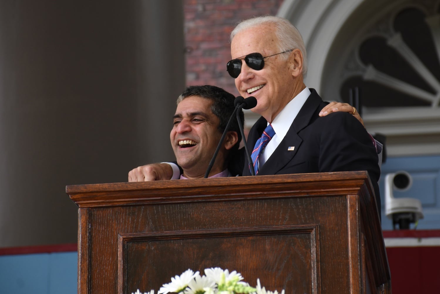 Dean of the College Rakesh Khurana and former Vice President Joseph Biden share a laugh on stage during Biden's speech at the Class Day Exercises.