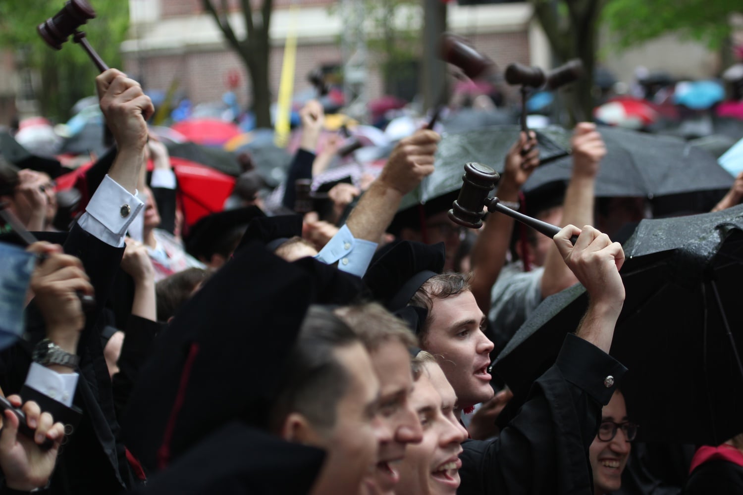 Law school graduates acknowledge their dean by raising their gavels during Morning Exercises.