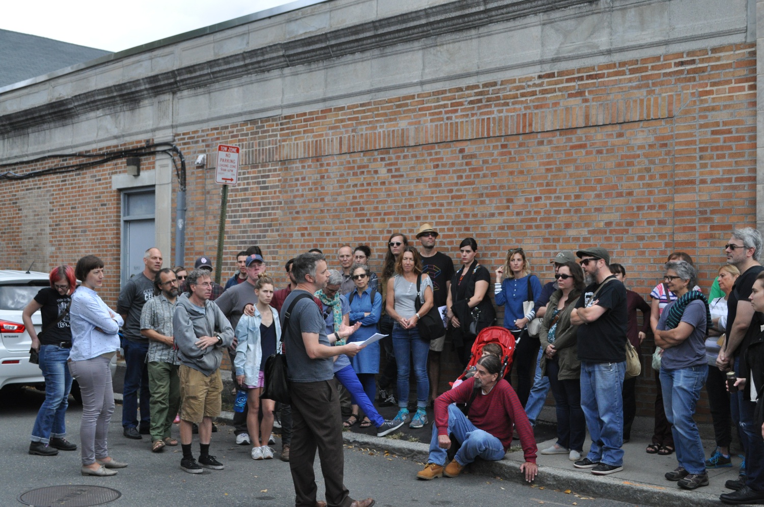 Tim Devin speaks to a crowd of over 60 people who have gathered for the counterculture walking tour of Inman Square.