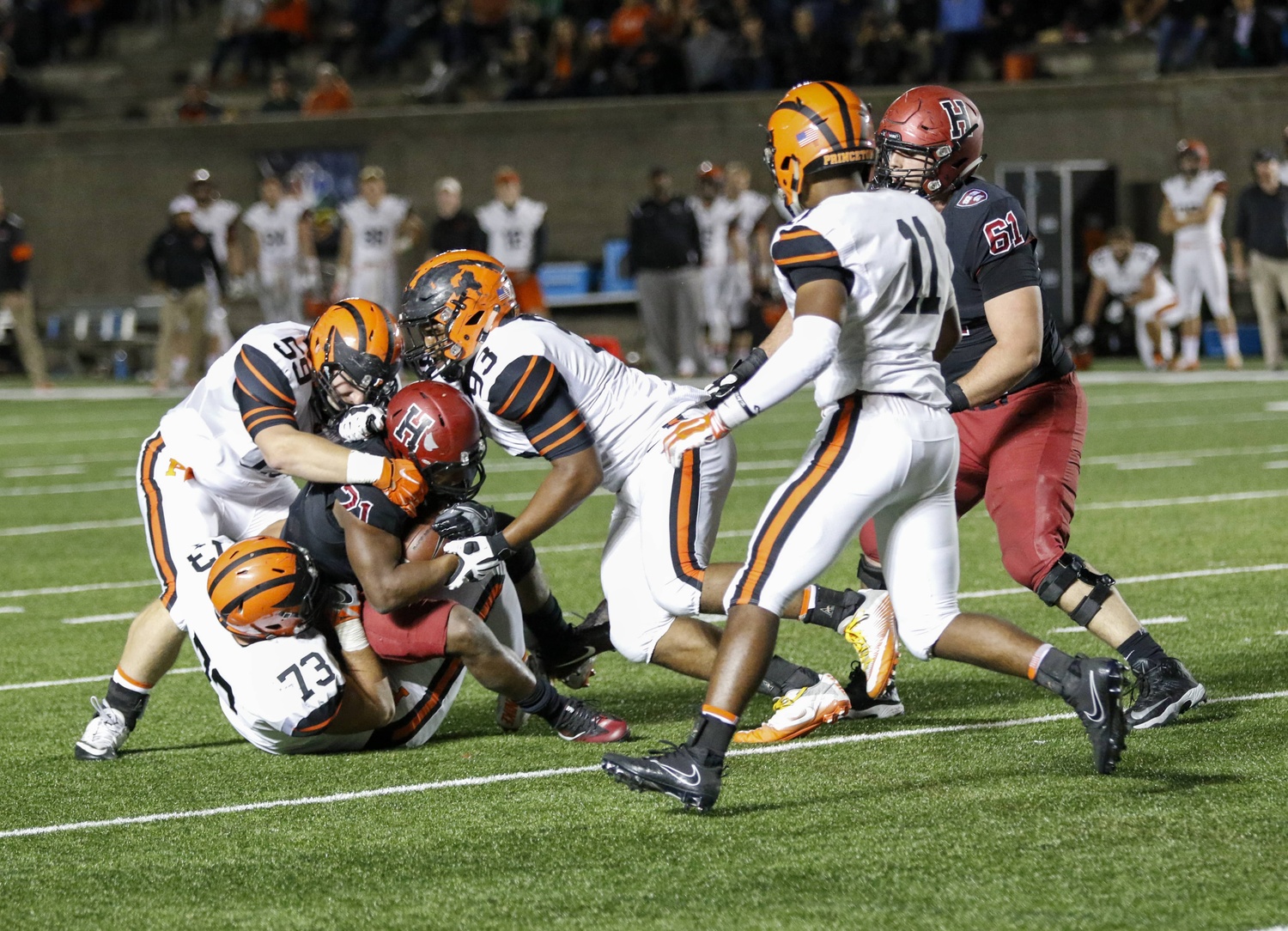Princeton defenders gang-tackle Crimson running back Charlie Booker.