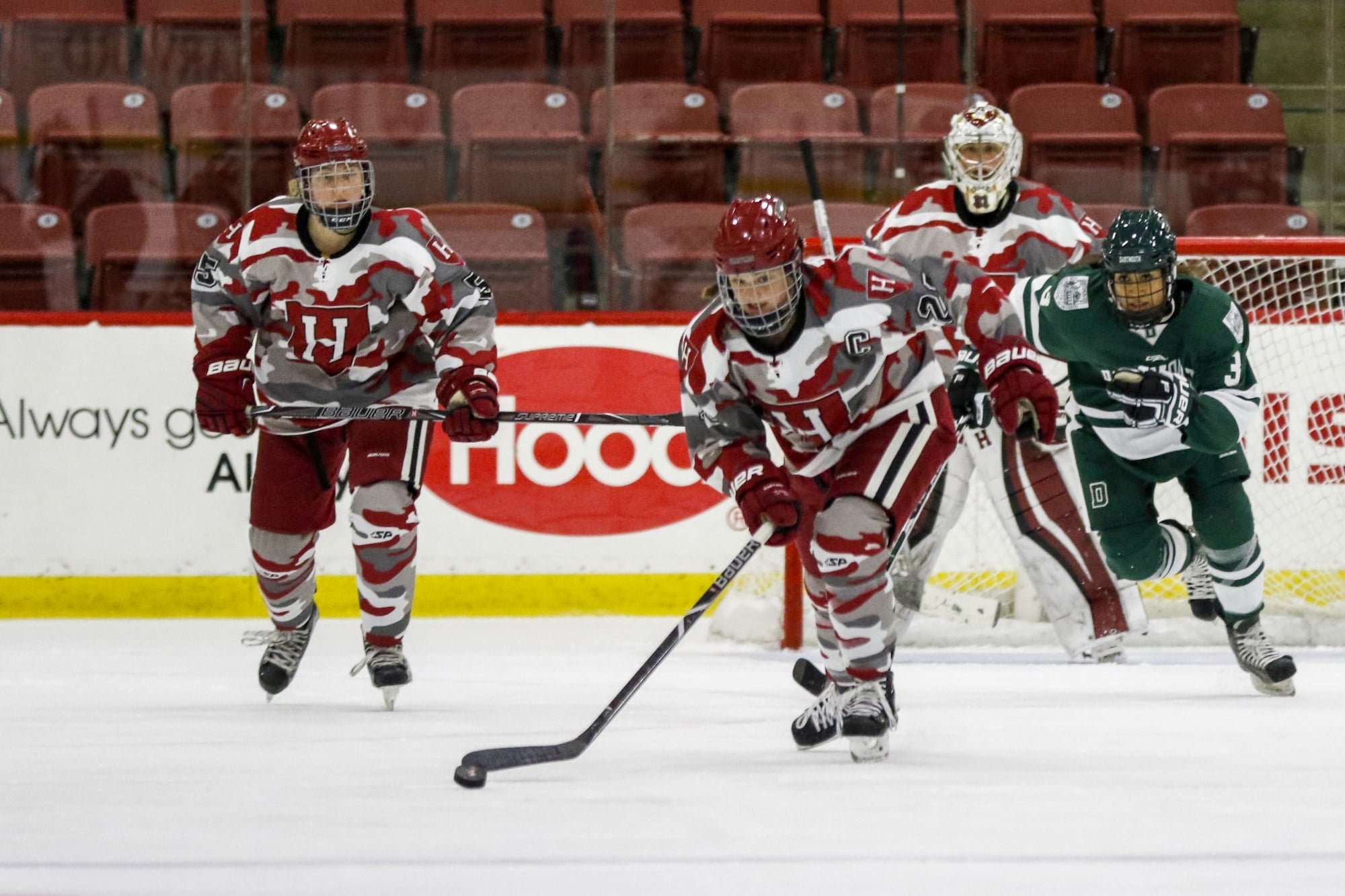 Captain Haley Mullins helps to clear the puck from Harvard’s half of the ice in the season opener against Dartmouth.