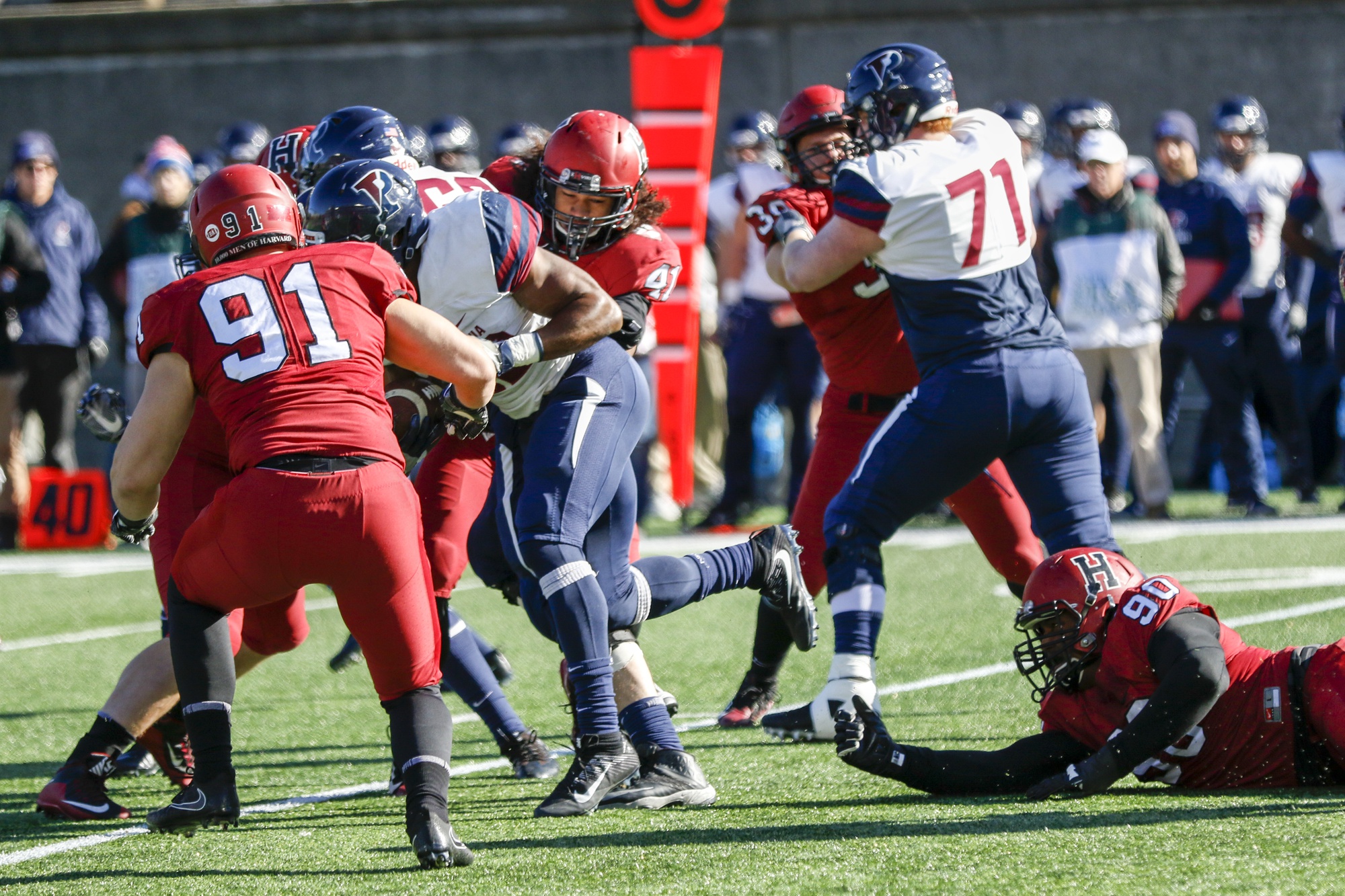 A swarm of Harvard defenders converges on a Penn ball carrier during last Saturday's action.