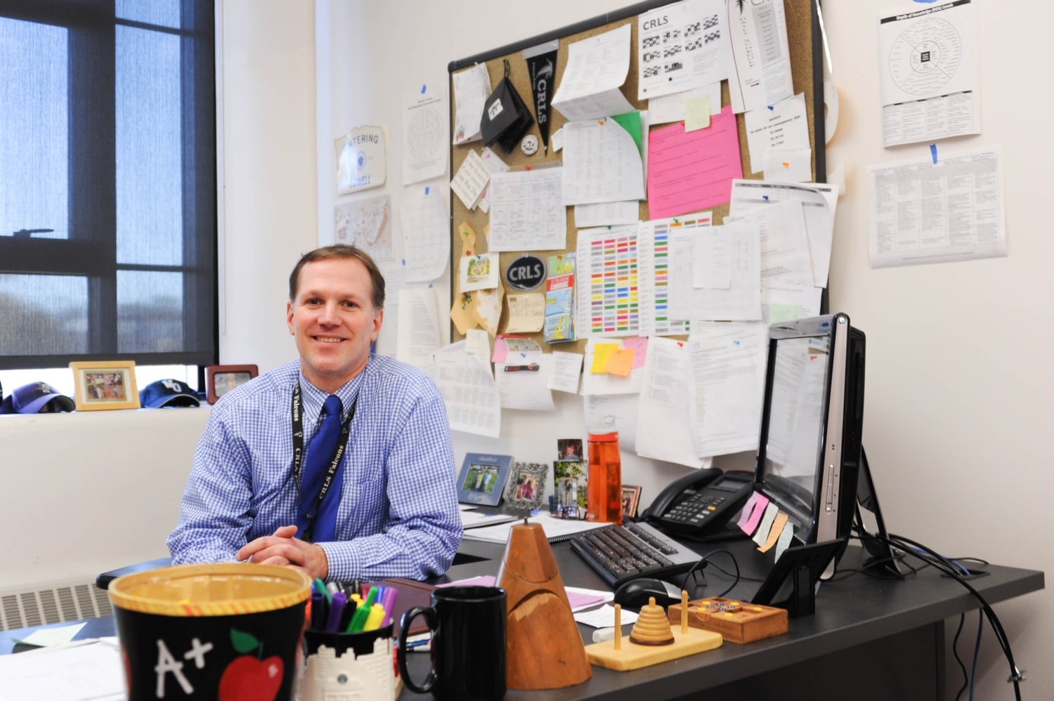 Jeff Gaglione, Dean of Mathematics at Cambridge Rindge and Latin School, poses for a photo at his desk Thursday afternoon.