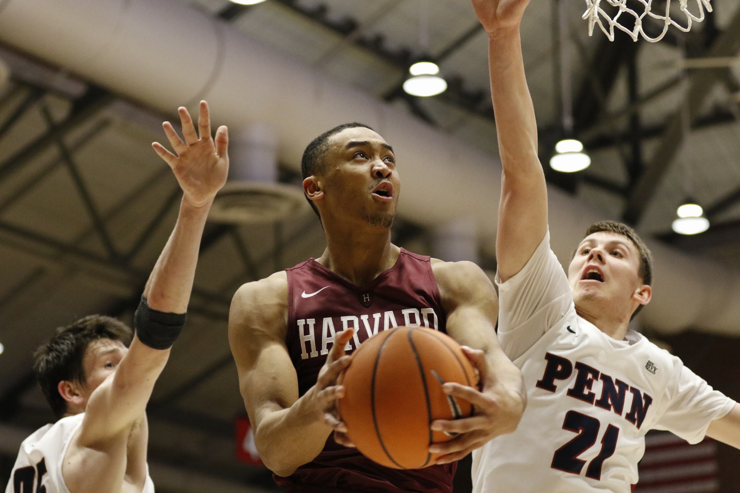 Sophomore forward Justin Bassey elevates past two Penn defenders in Saturday's victory. Bassey finished with 12 points in the contest