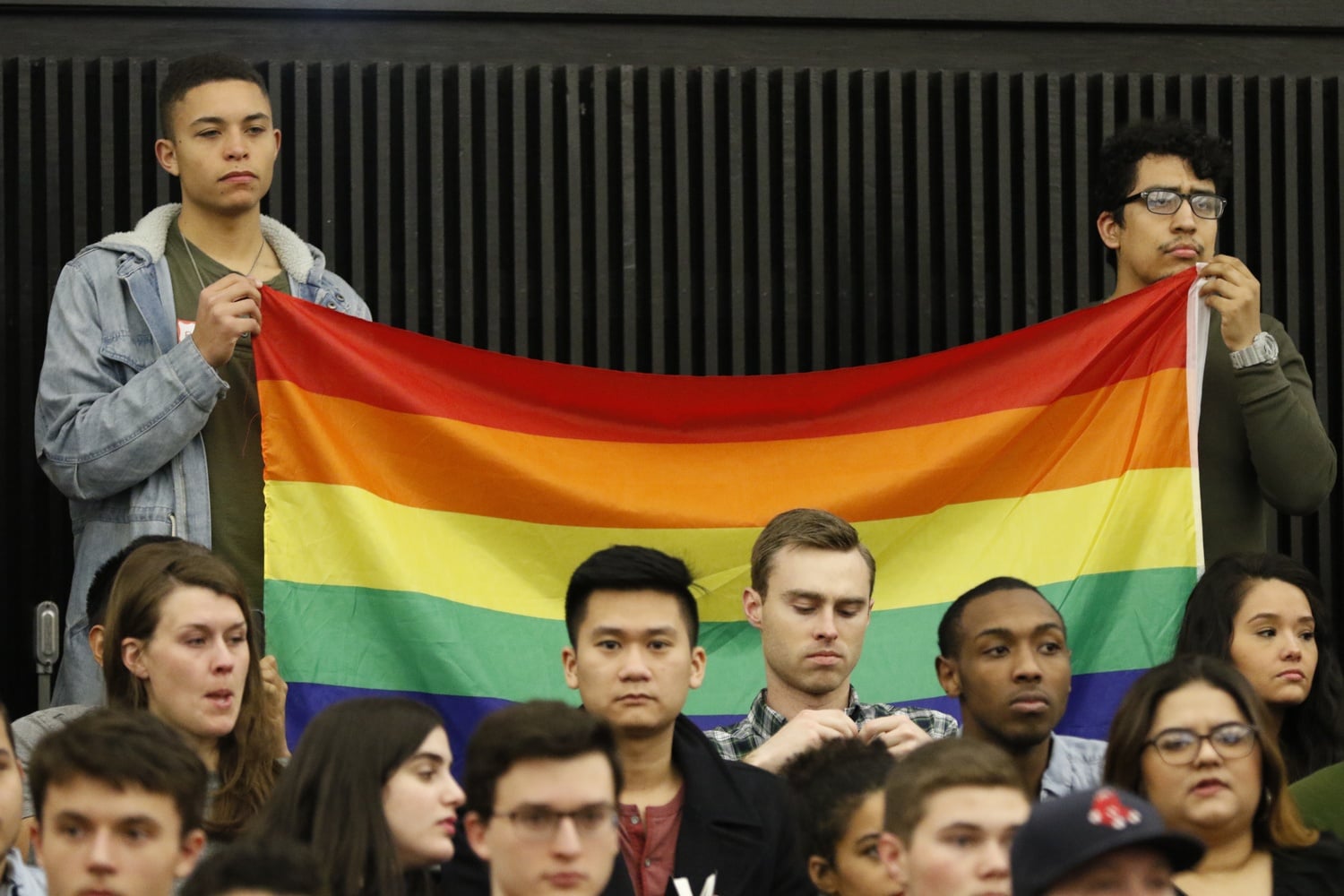Students hold up a rainbow flag in protest of Jackie Hill-Perry. Religious group Harvard College Faith and Action invited the "ex-gay" speaker to their weekly meeting Friday night.