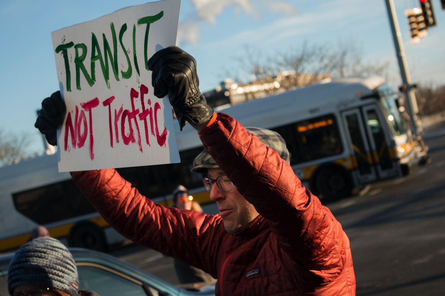 A protester holds up a sign at the 'Transit Not Traffic' rally.