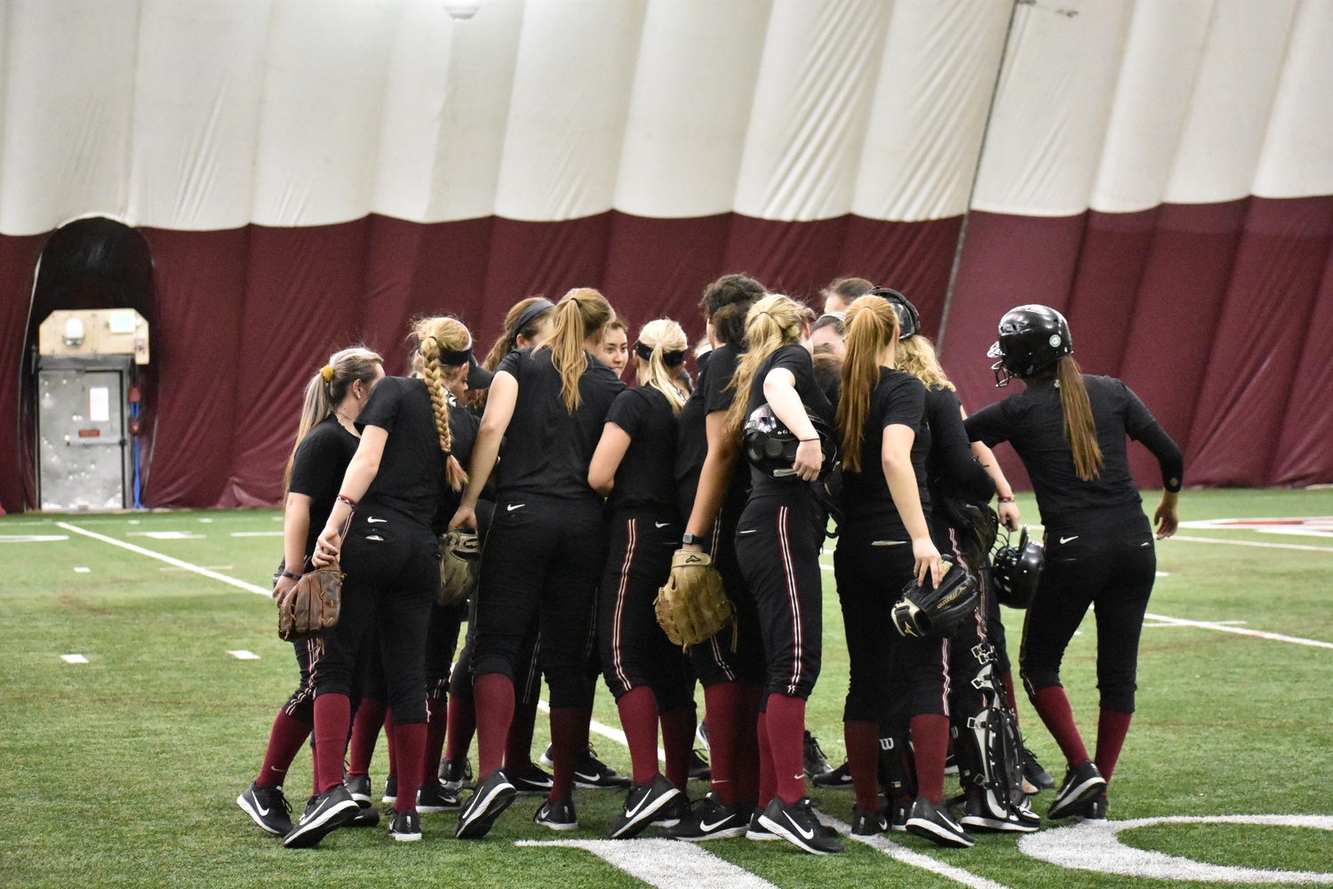 The softball team comes together during a winter practice.