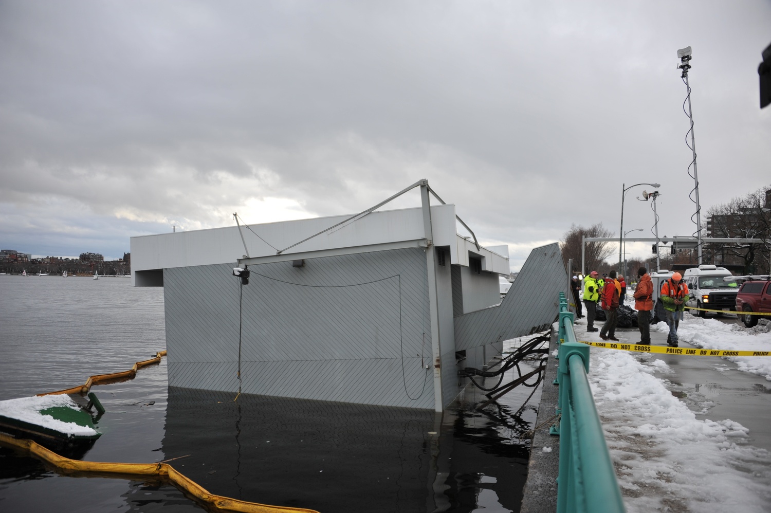 The Harvard Sailing Center sinks into the Charles River on Friday.