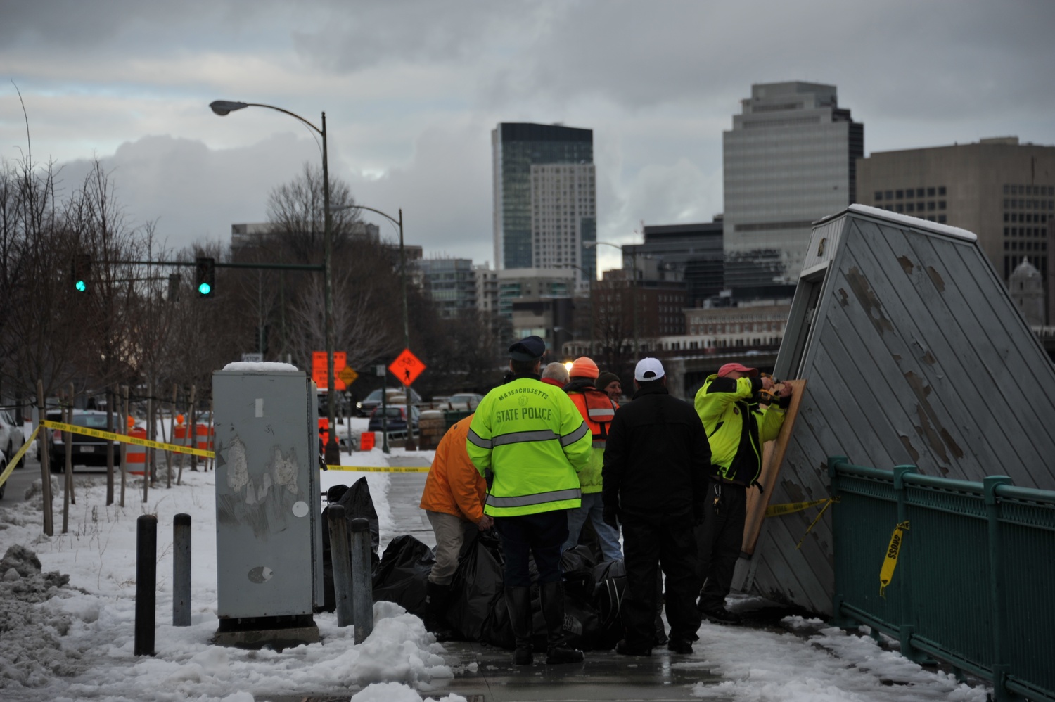 Policemen gather by the sinking Harvard Sailing Center Thursday.