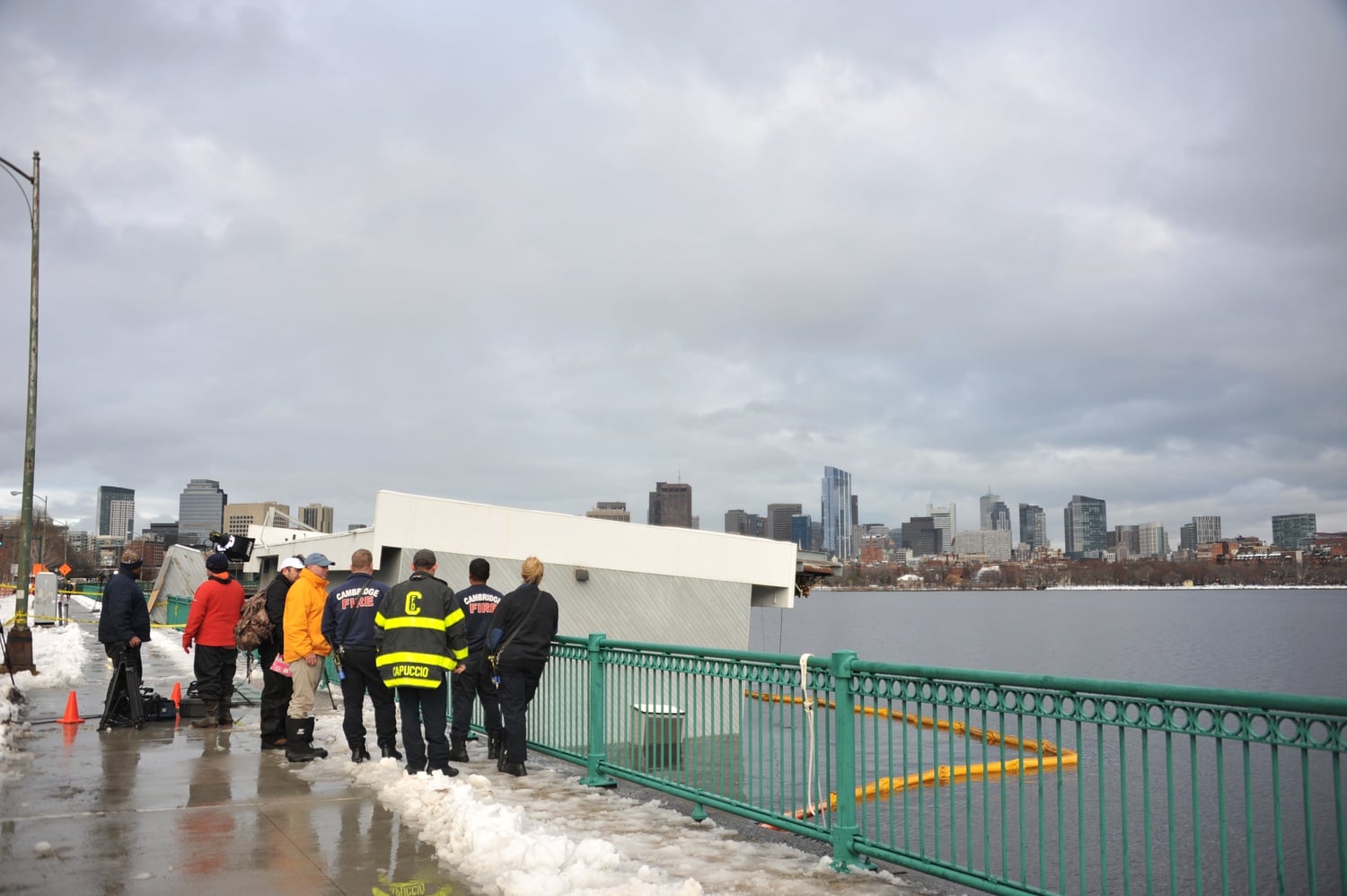 The Harvard Sailing Center bobs in the water after sinking partially into the Charles River Thursday.