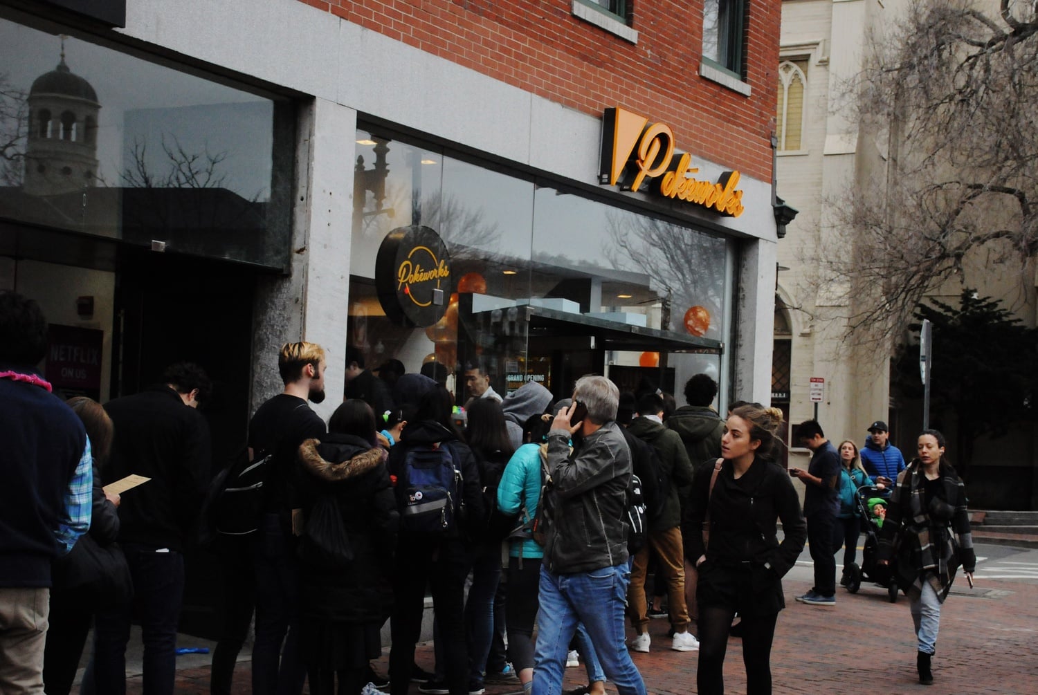 A line forms outside Pokeworks Saturday during the official grand opening of the restaurant in Harvard Square.