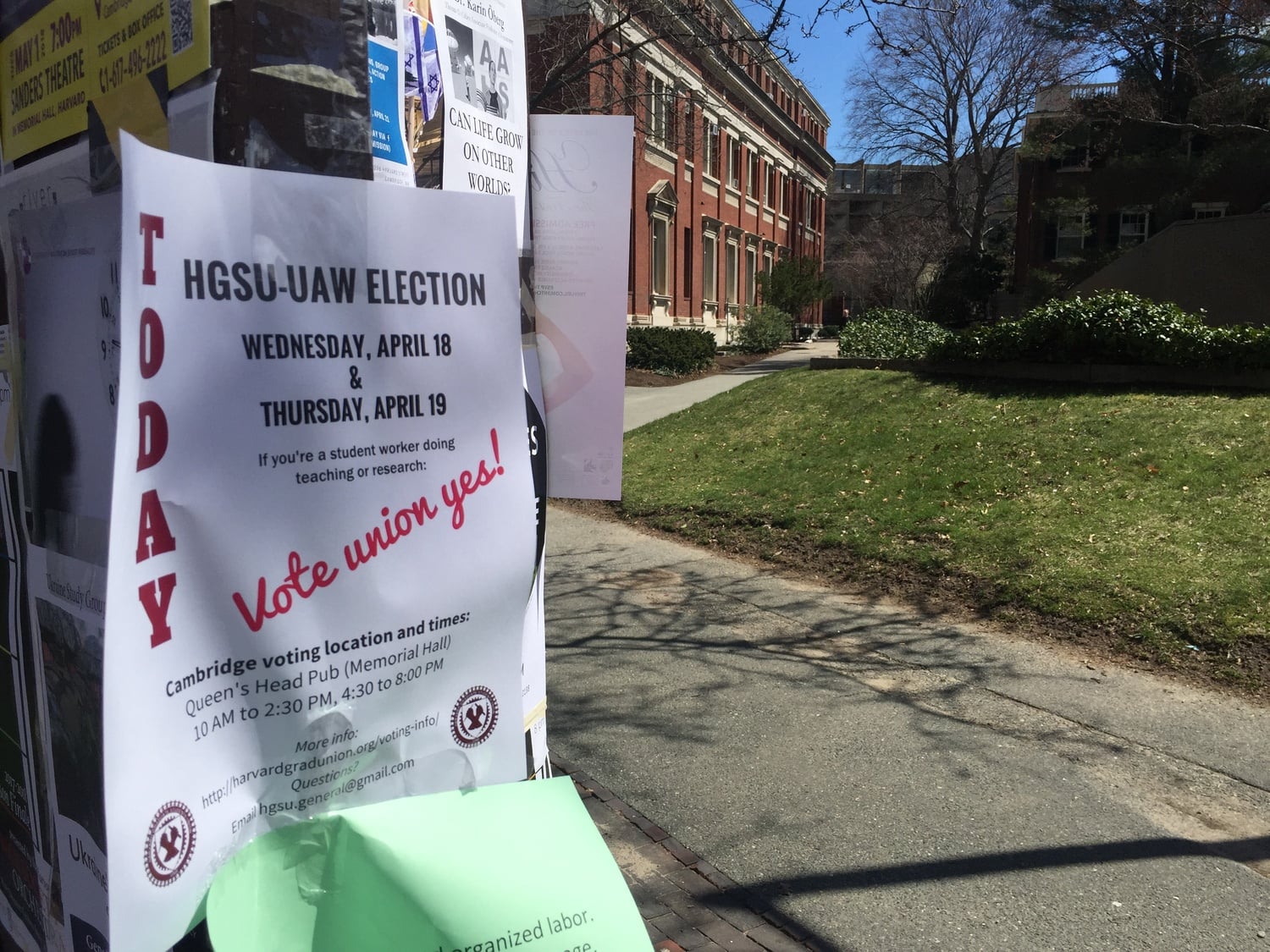 A pro-unionization poster hangs taped to a campus postering board on the first day of voting in Harvard's second unionization election.