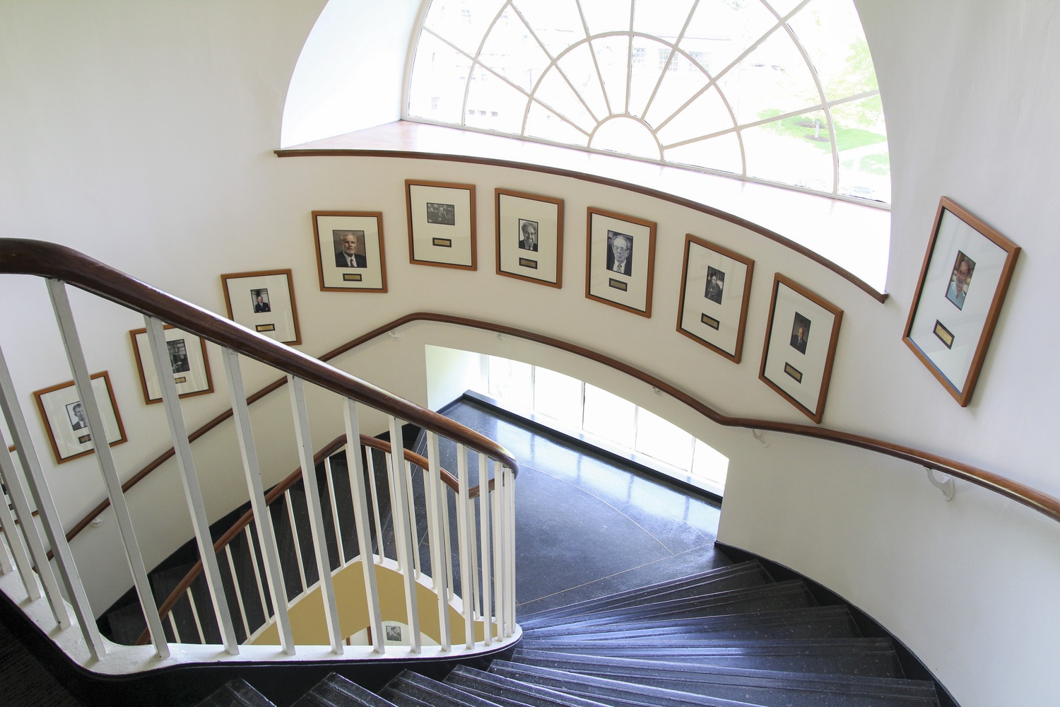 Portraits of faculty members from the Department of Economics line a staircase in the Littauer Center. 