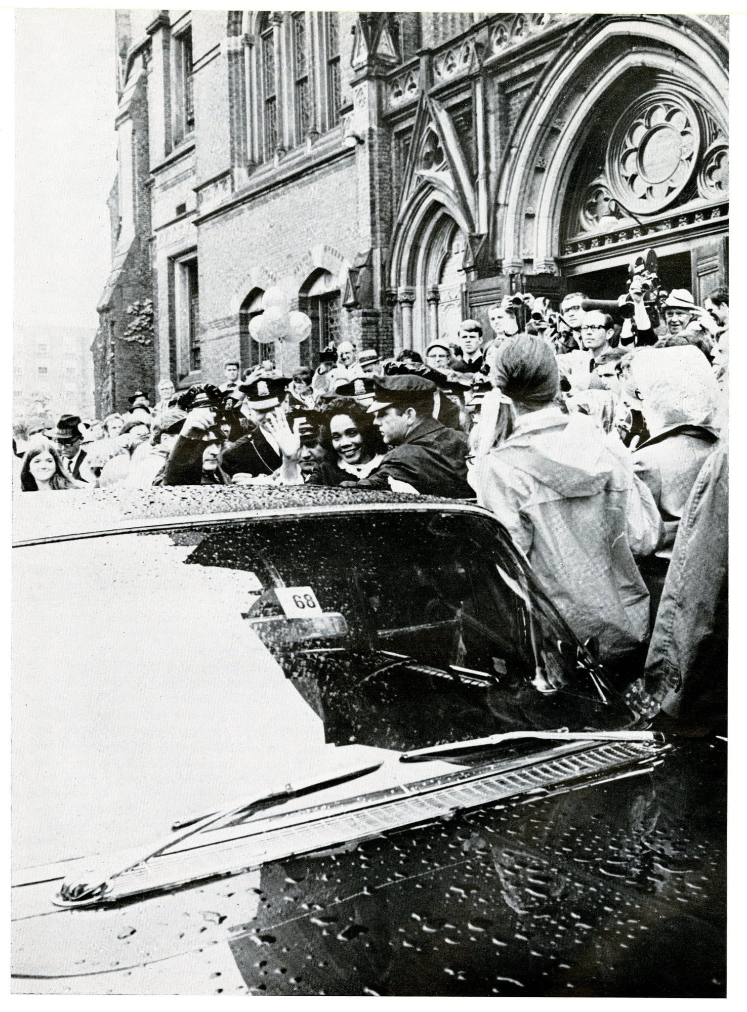 Coretta Scott King enters a car amidst throngs of press and students outside of Memorial Hall following her address to the Class of 1968. 