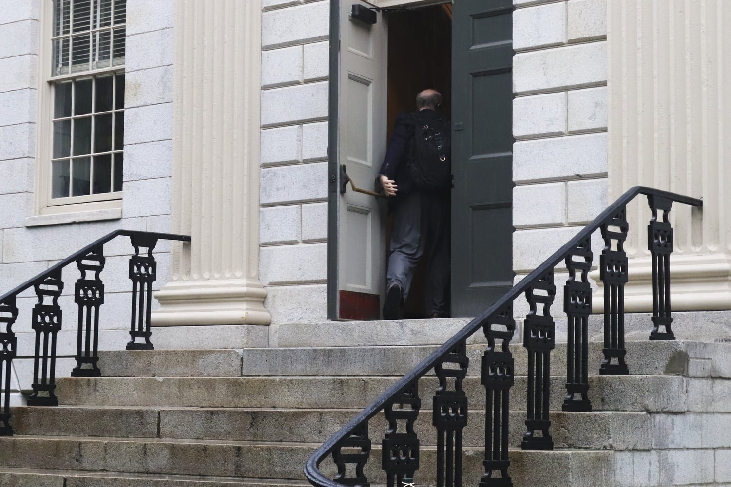 Professors enter University Hall to attend a meeting of the Faculty Council on a rainy Wednesday afternoon in Sept. 2018.