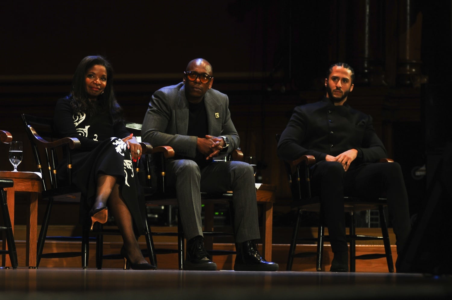 Pamela Joyner (left), Dave Chappelle (center), and Colin Kaepernick (right), all recipients of the award, listen to a speech during the medal ceremony.