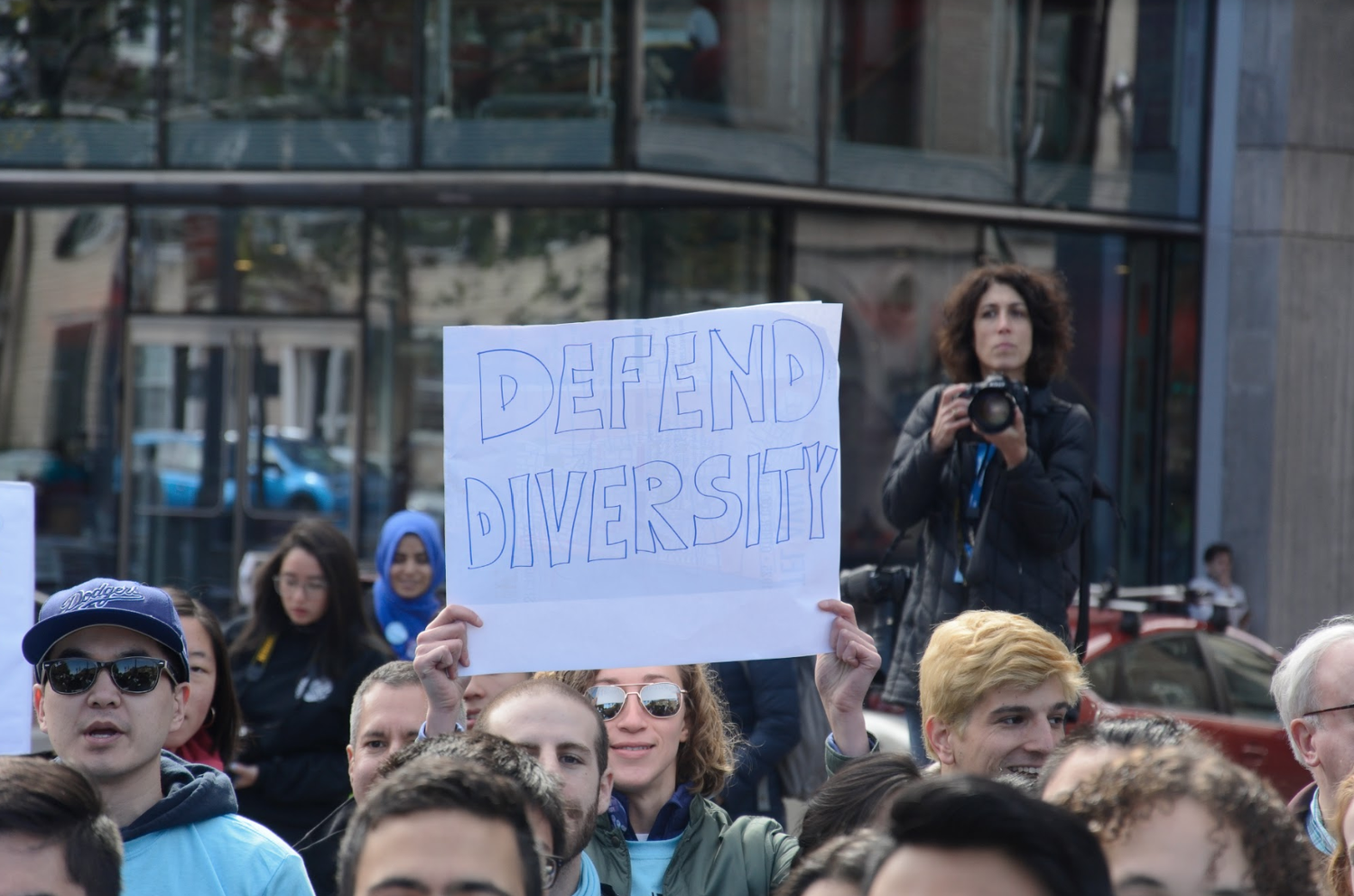 Pro-Harvard protesters wield signs in support of the College's race-conscious admissions policies at a rally Sunday.
