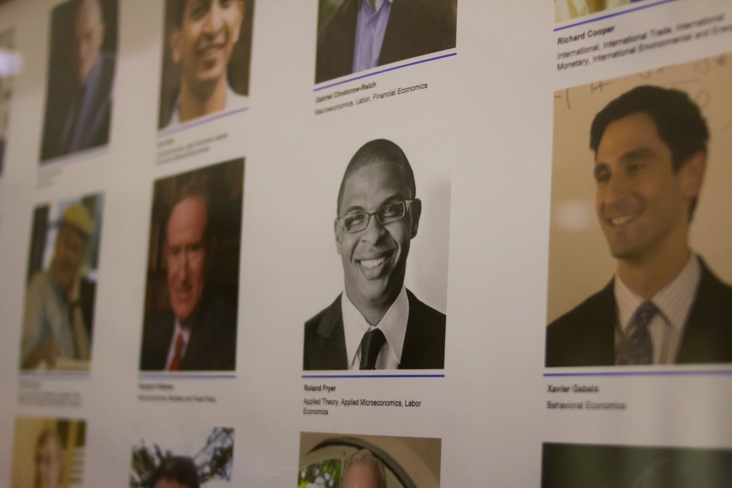 A headshot of Economics professor Roland G. Fryer, Jr. among other department faculty in the Littauer Center.