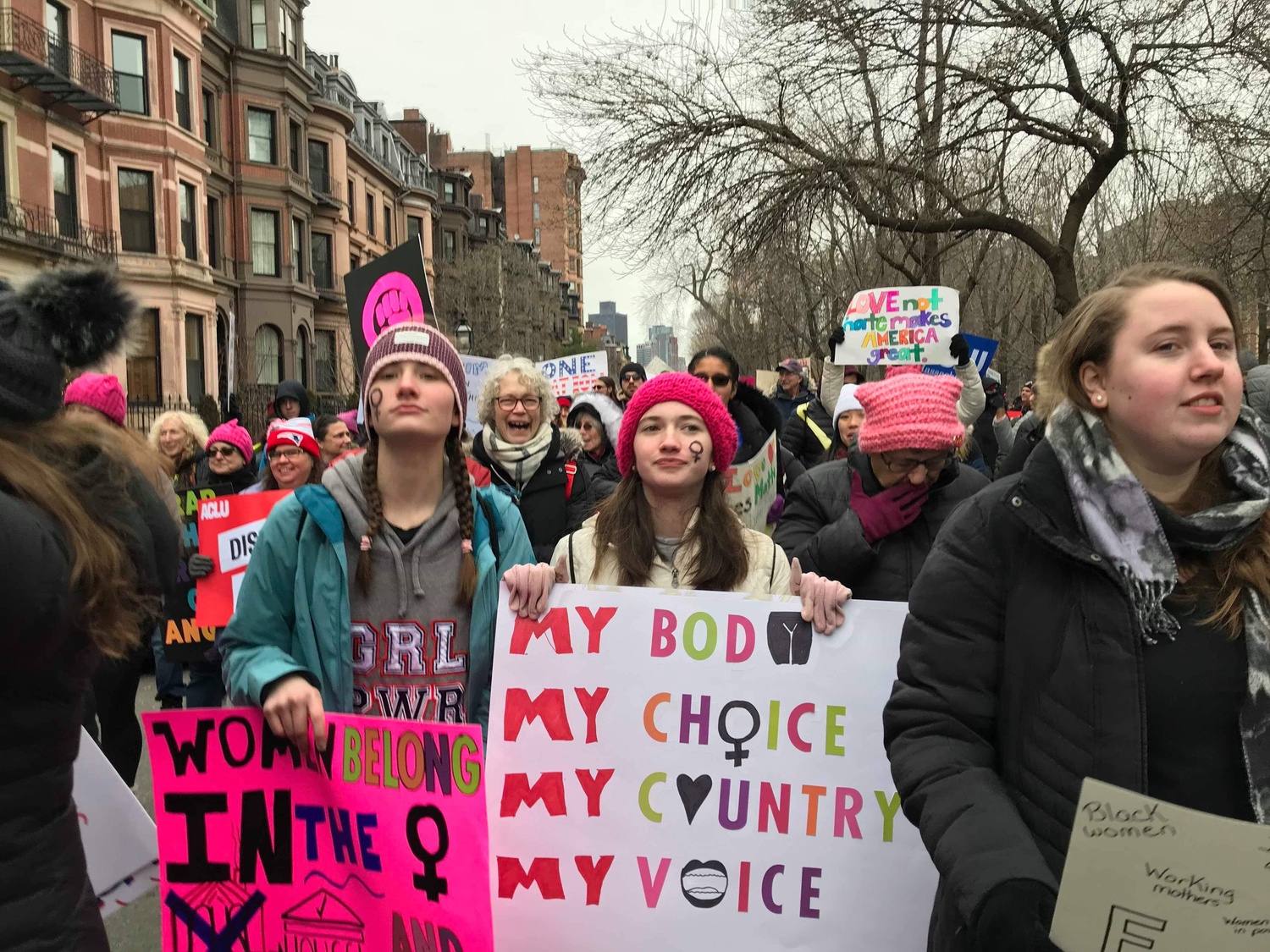 Protesters at the 2019 Boston Women's March wield colorful signs as they march from Boston Common.