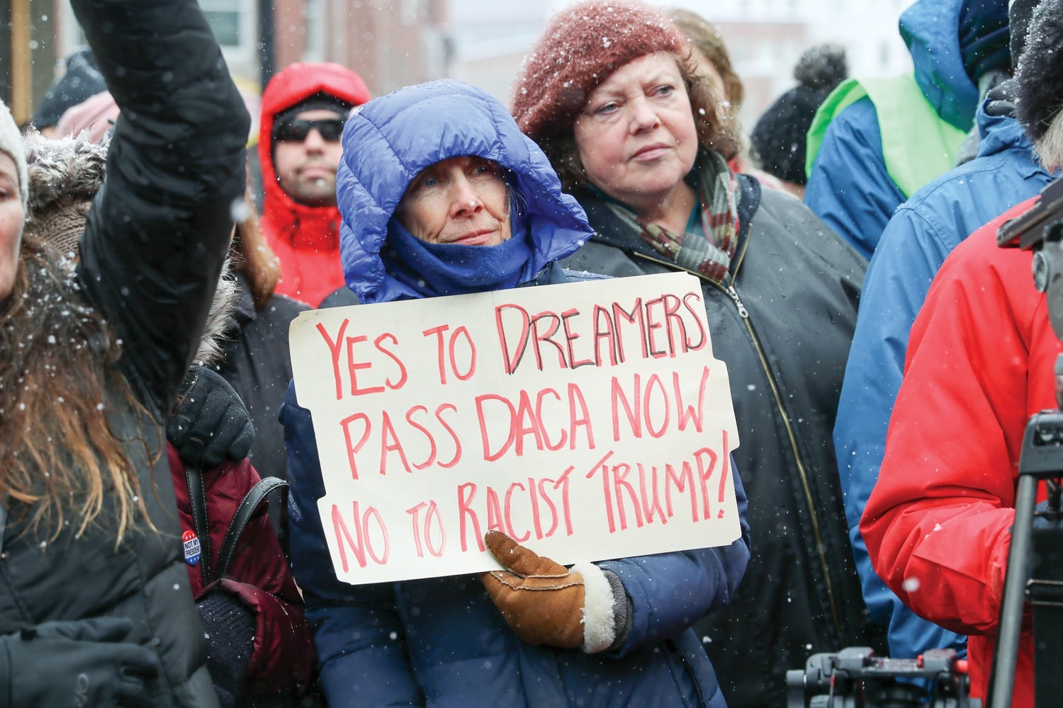 A woman holds a sign supporting Deferred Action for Childhood Arrivals recipients at a Monday protest, criticizing President Donald Trump's declaration of a national emergency to build a border wall.