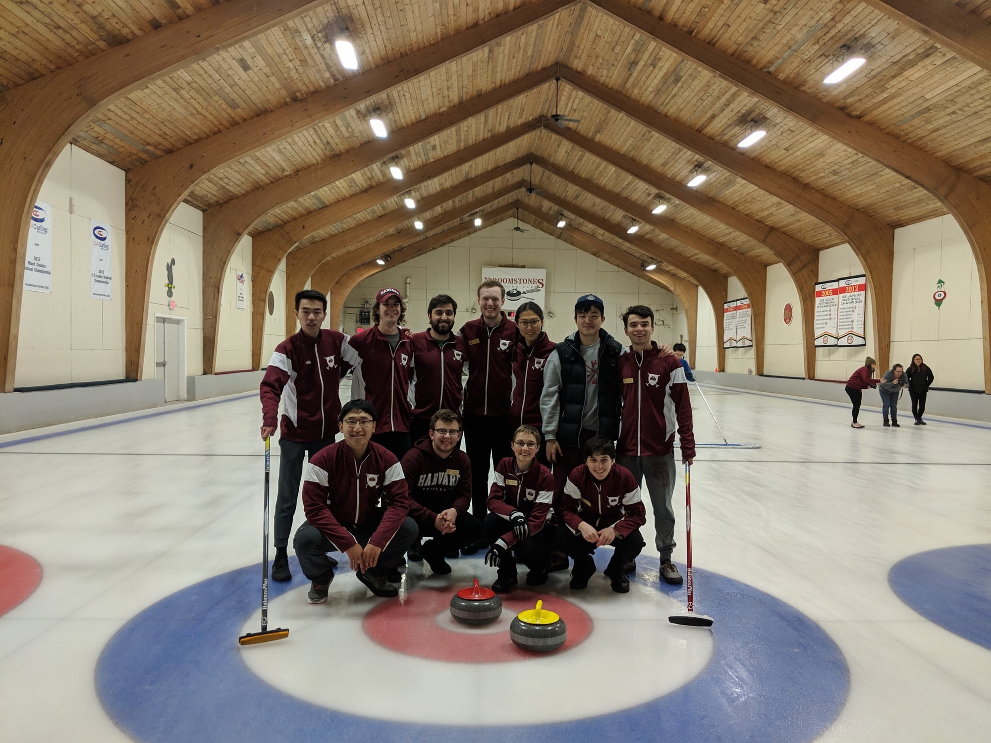 The Harvard Curling Club poses holding their equipment: stones and brooms used during competition.