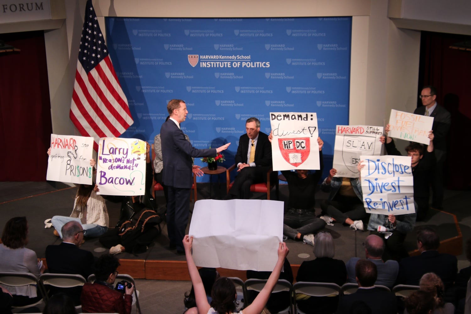 Protestors from Divest Harvard and the Harvard Prison Divestment Campaign interrupt an Institute of Politics event featuring University President Lawrence S. Bacow Thursday evening.