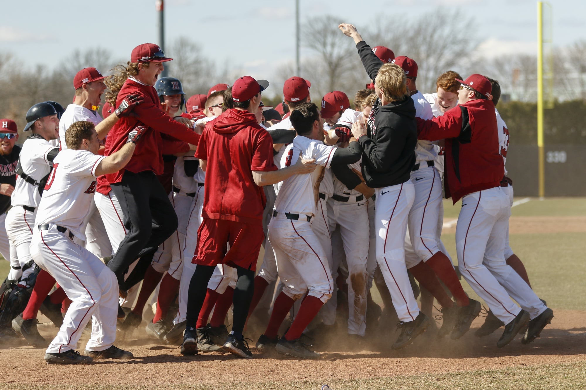 The team celebrates after a nine-run, ninth inning to take the first game against Yale.
