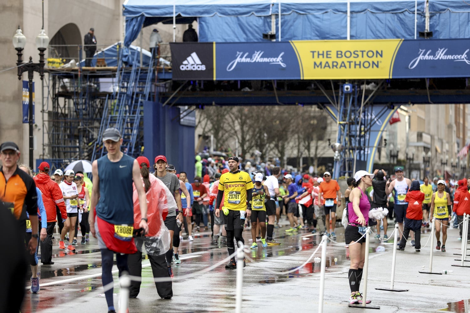 After finishing the race in the rain, Boston Marathon runners leave the course on Monday afternoon.