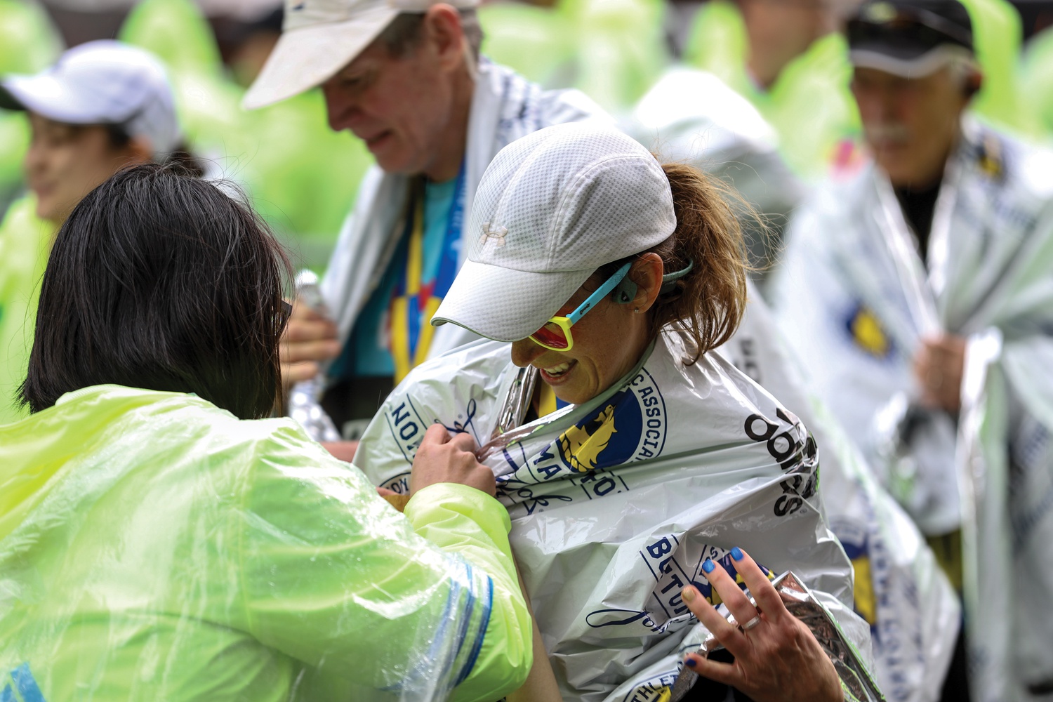 A marathon participant has a mylar blanket wrapped around her after concluding the race.
