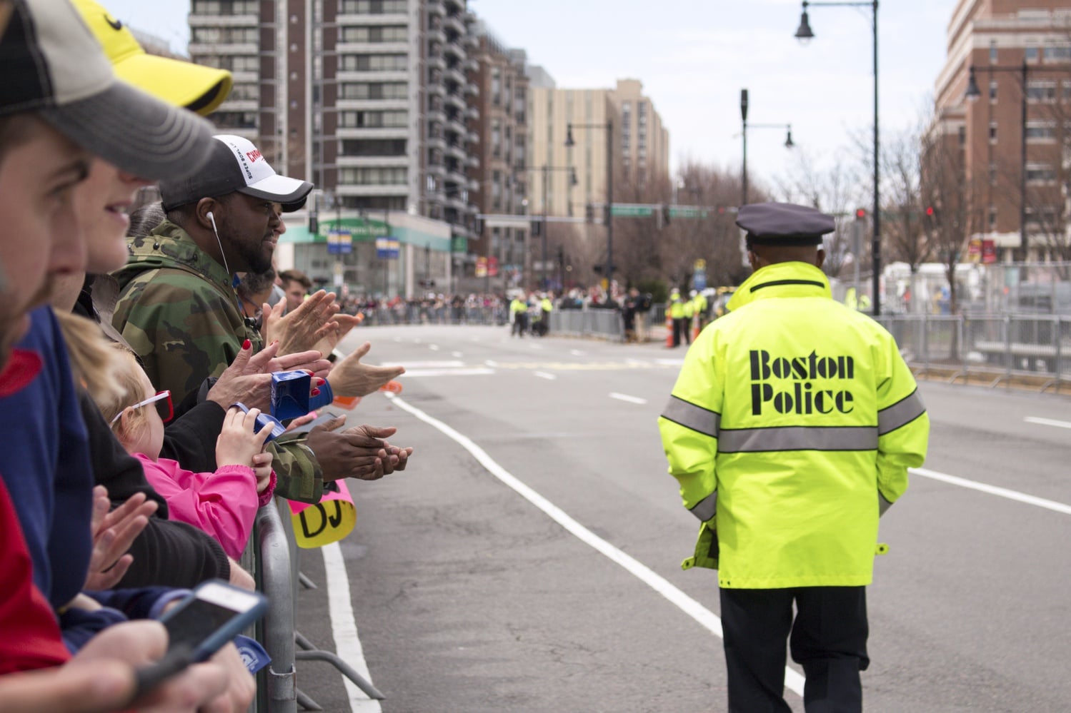 Crowds cheer on Boston Marathon runners as the Boston Police ensure the safety of the participants and onlookers.