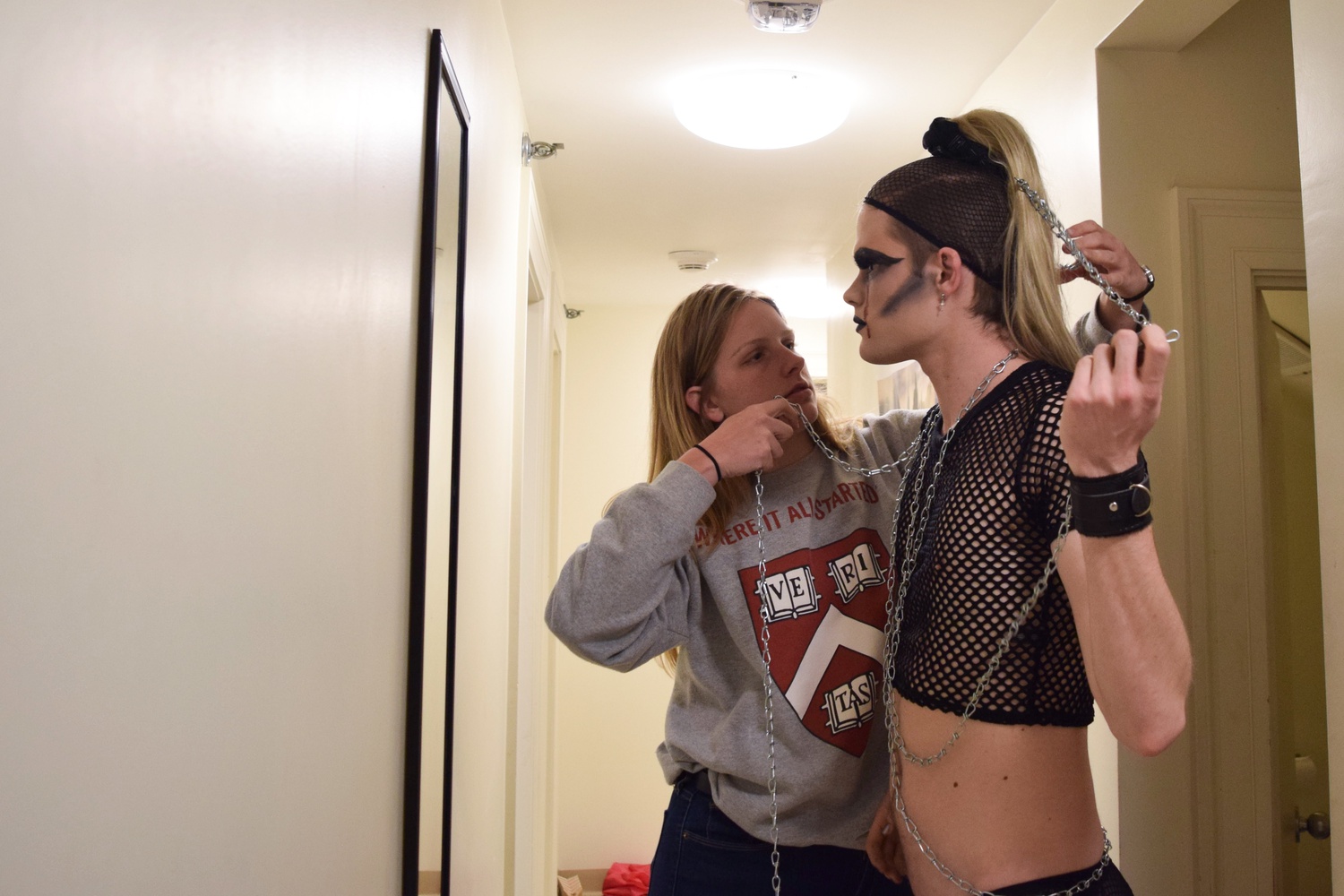 Kira Telgen '19 helps Casey R. Goggin '19 wrap chains around their body as the last step of Goggin becoming their drag persona Ms. Eddy Piss.