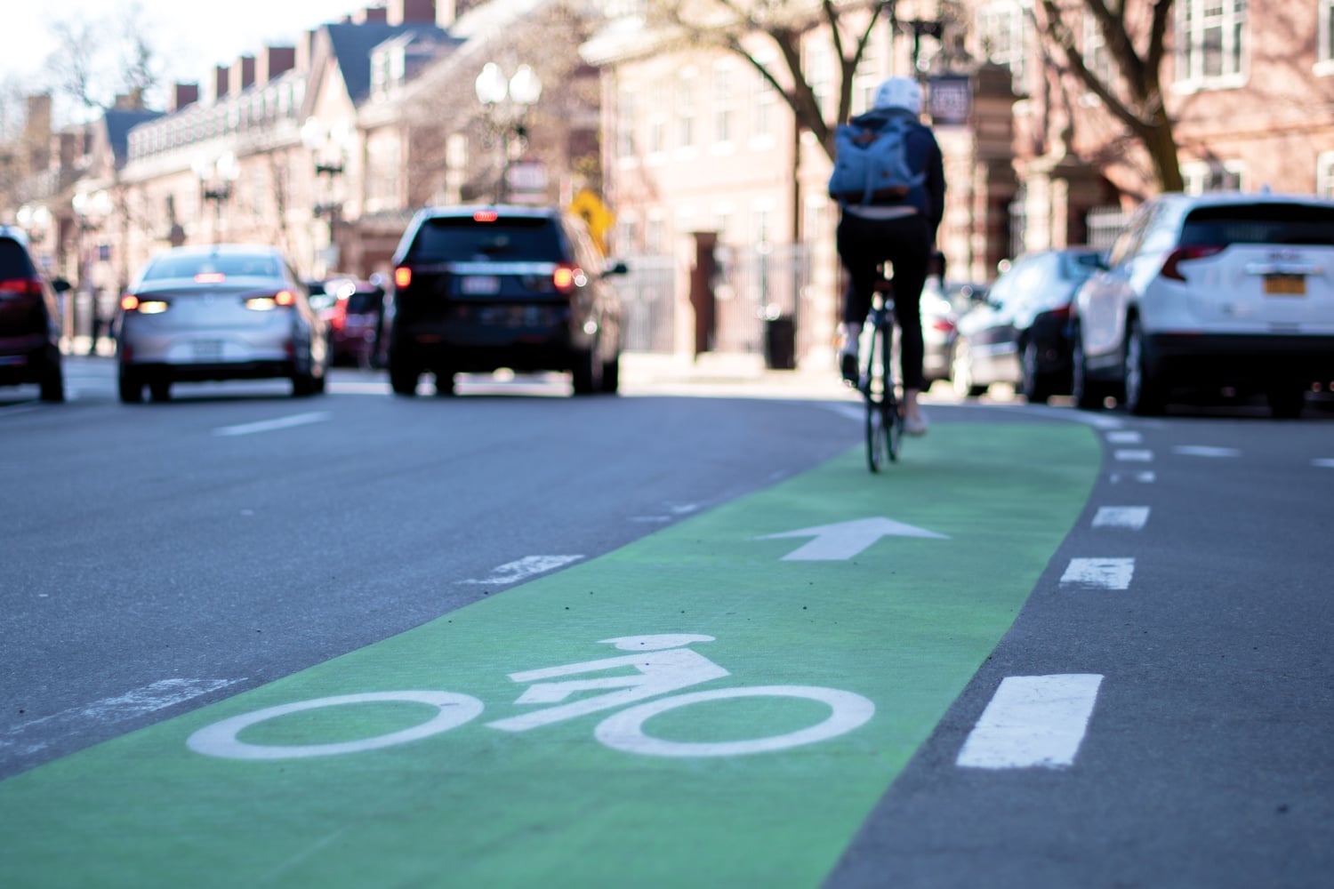 A biker rides through Harvard Square in the bike lane on Massachusetts Avenue.