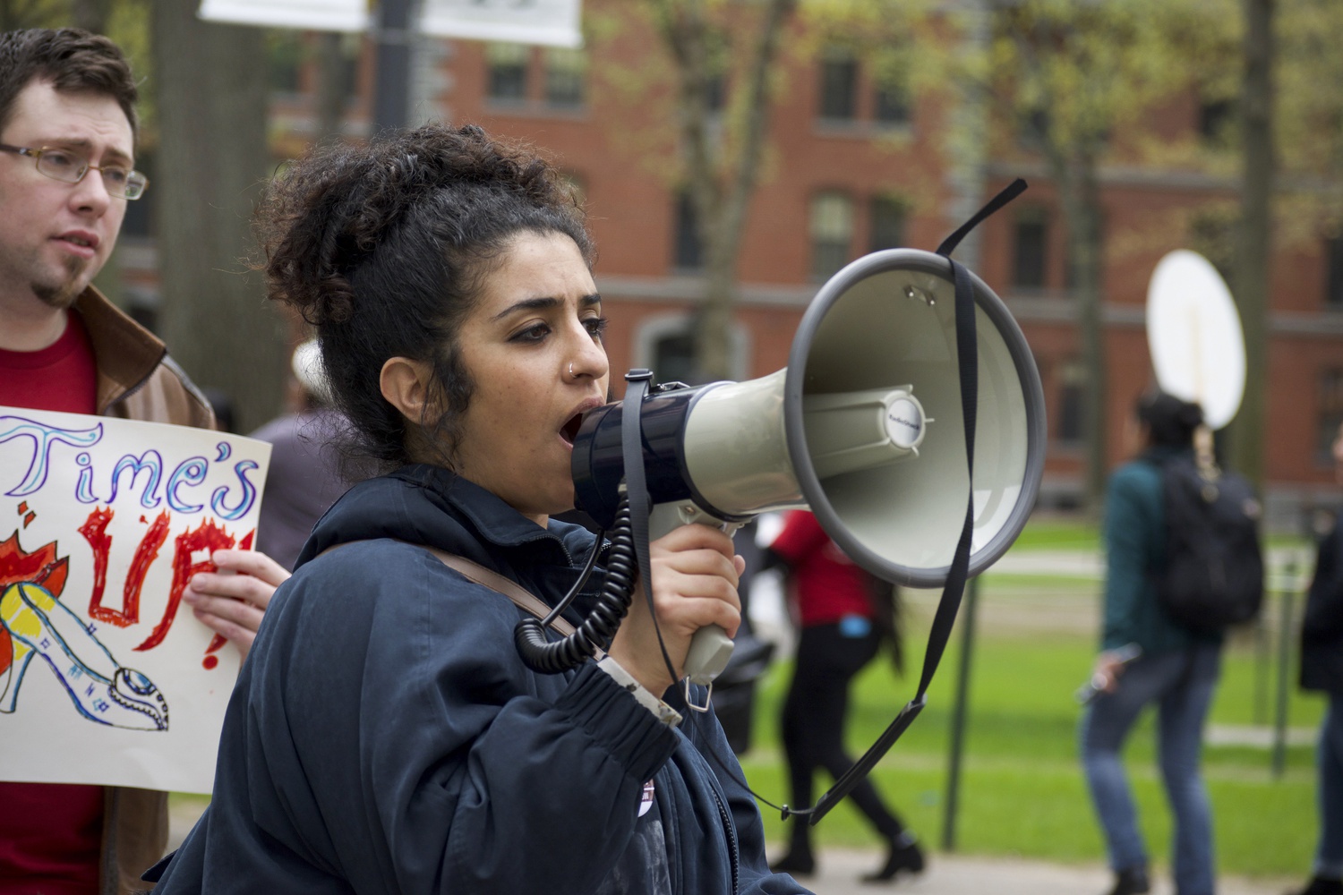 A protester speaks to the crowd as she leads the crowd on their march in Harvard Yard. Protestors sang organized chants during the march.
