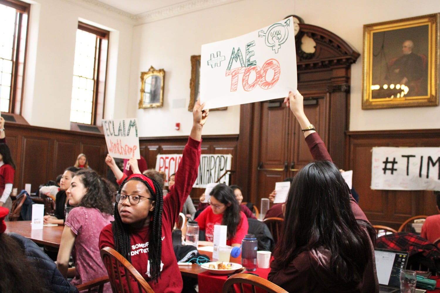 Students held up signs reading "#MeToo" at a Friday sit-in in Winthrop House's dining hall in protest of Dean Sullivan's decision to represent Hollywood producer Harvey Weinstein.