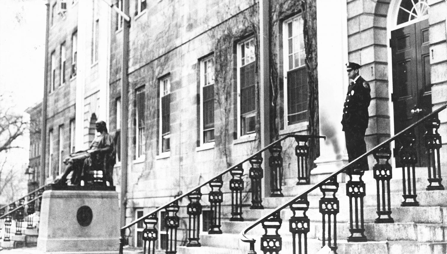 A guard stands watch at one of University Hall's entrances in 1969.