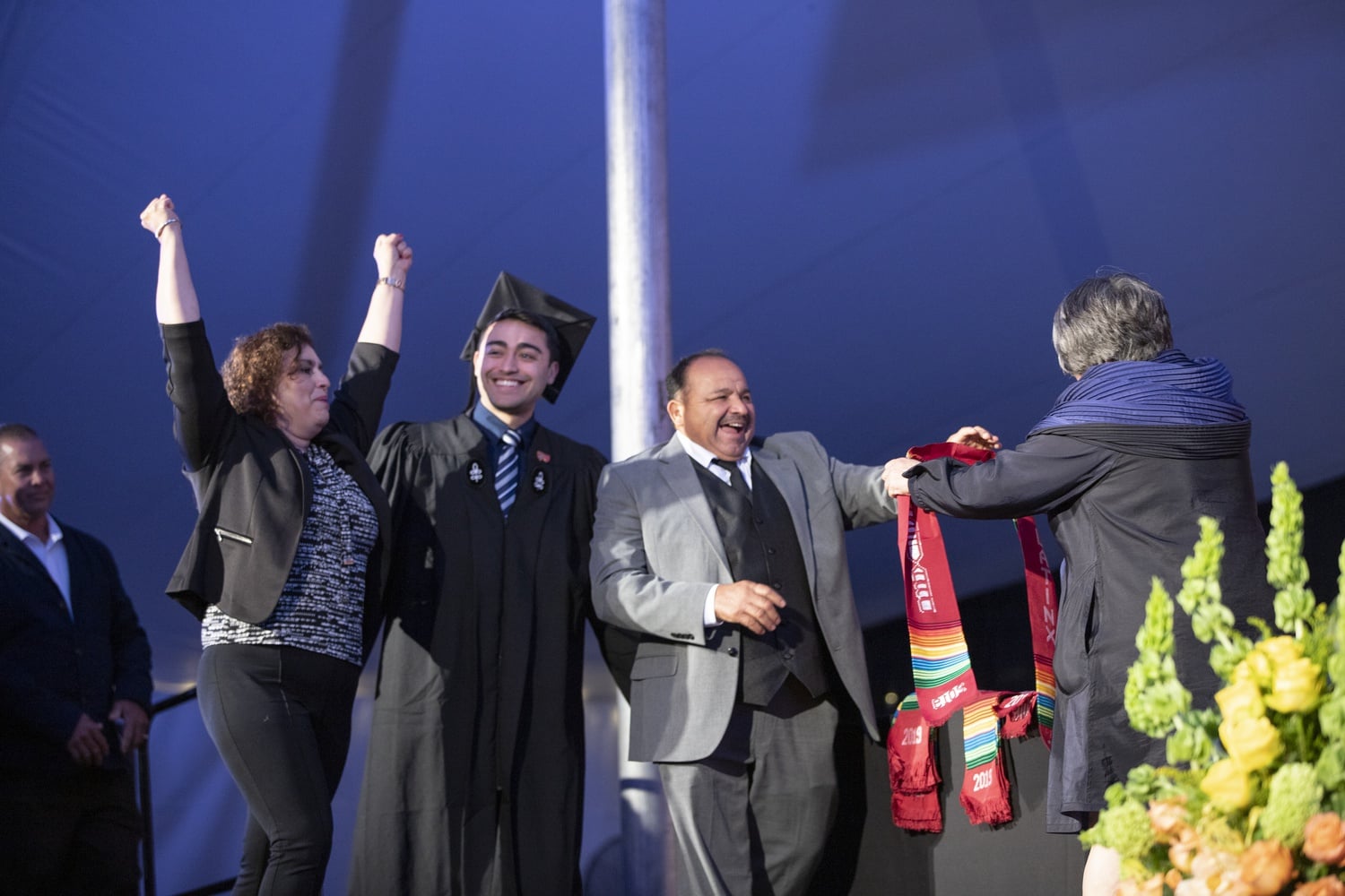 Family members draped graduating students with Latinx stoles as they walked on stage. The Latinx Commencement took place Tuesday evening at Radcliffe Yard.