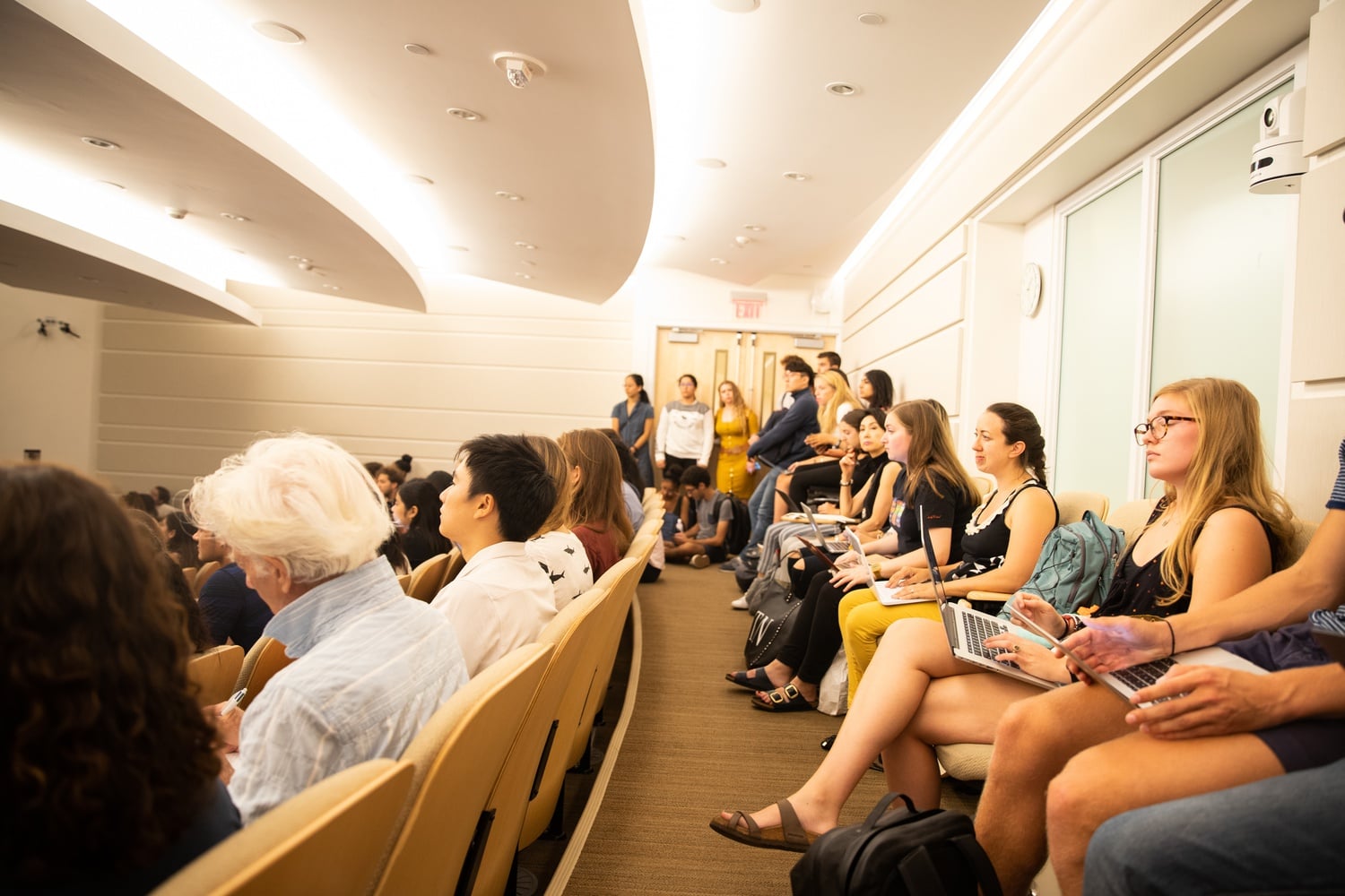 Students crowd into a lecture hall in William James to shop GENED 1154: "The Science of Happiness."