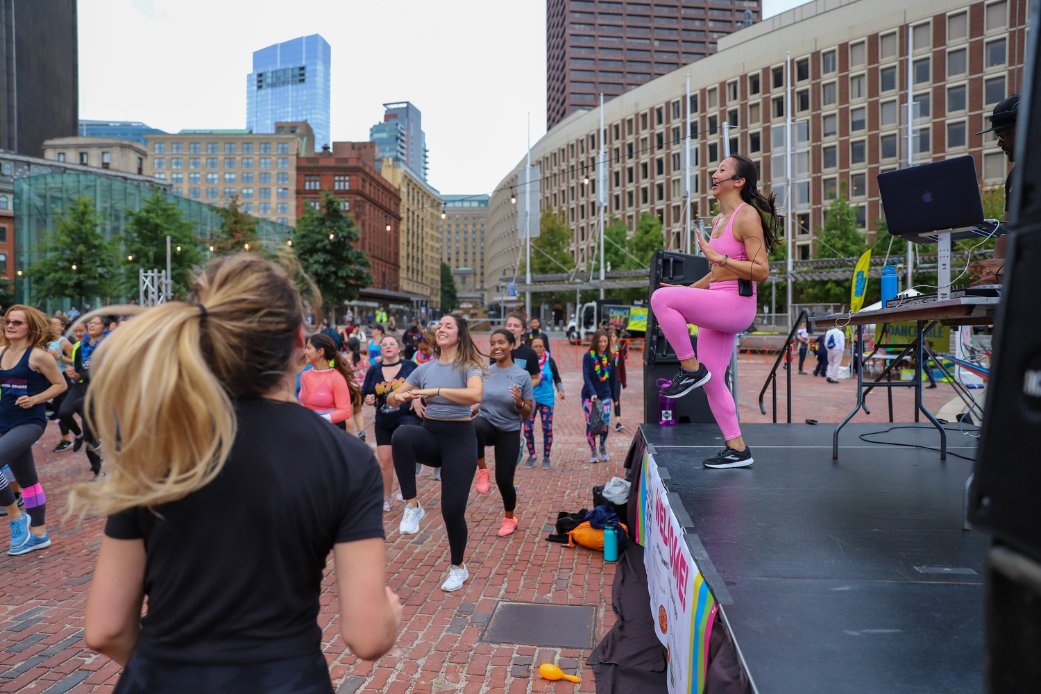 Rebecca T. Pham, an instructor at 305 Fitness in Boston, leads the attendees of Boston's Social Fitness Festival in an active workout.