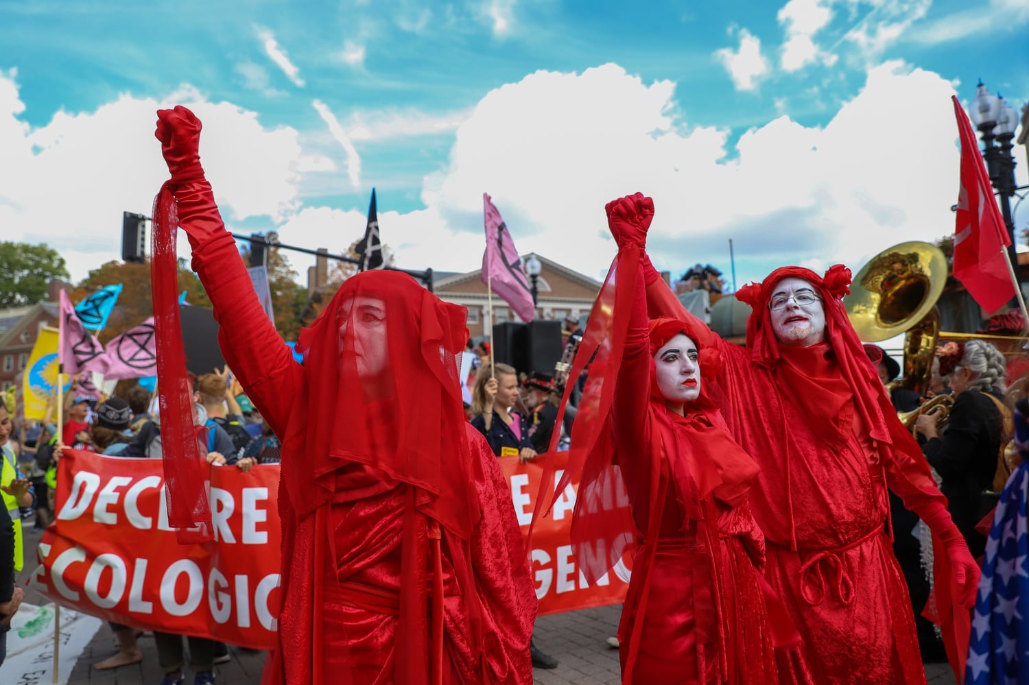 Members of the "Red Rebel Brigade" joined the Extinction Rebellion's die-in and rise up in Harvard Square during the HONK! parade to fight for government action regarding climte change, immigrant justice, and affordable housing.
