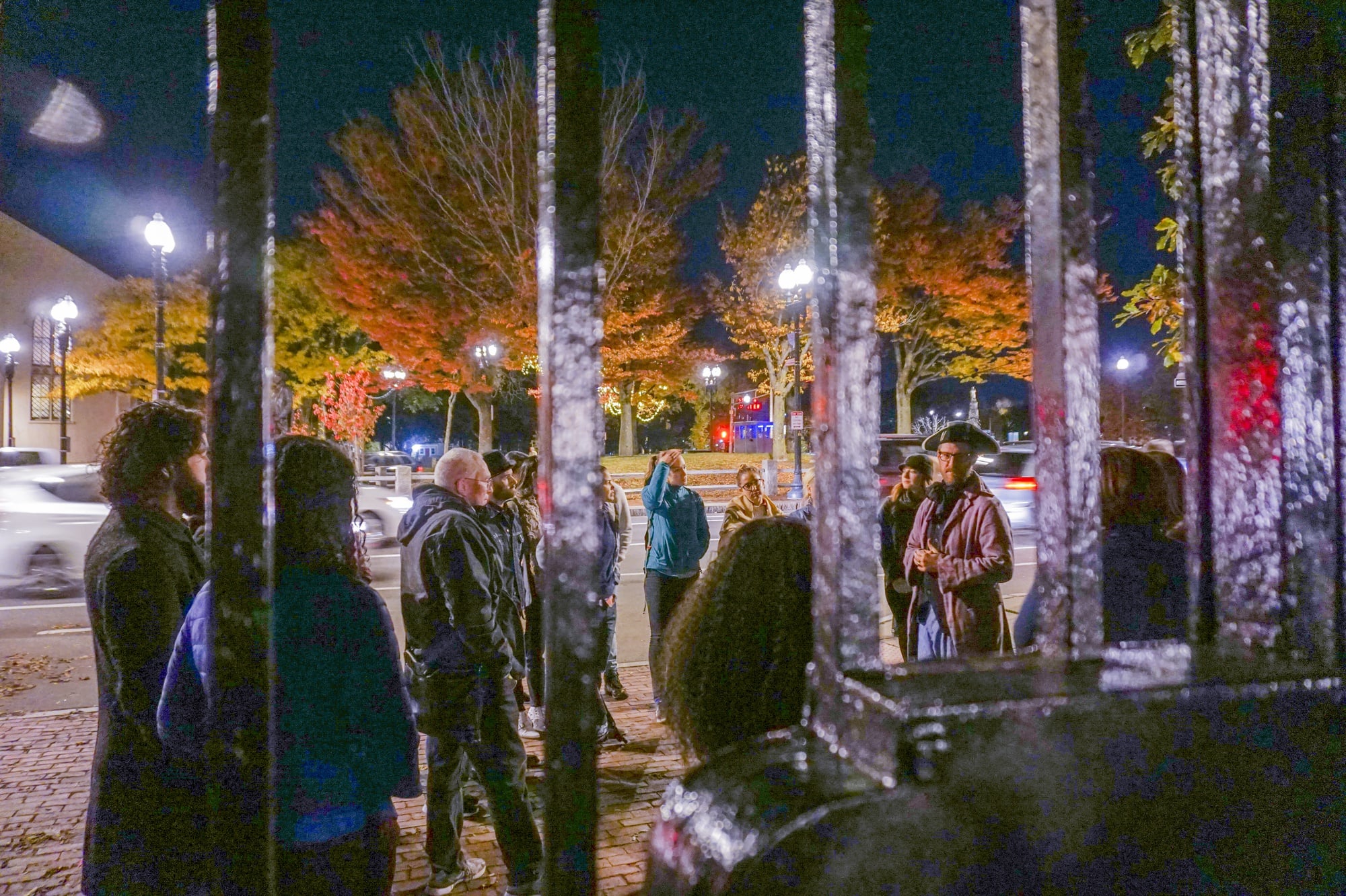 A Cambridge Historical Tours tour guide tells a tour group a story about a Harvard Medical School professor who killed someone who lent him money during a Harvard Square ghost tour.