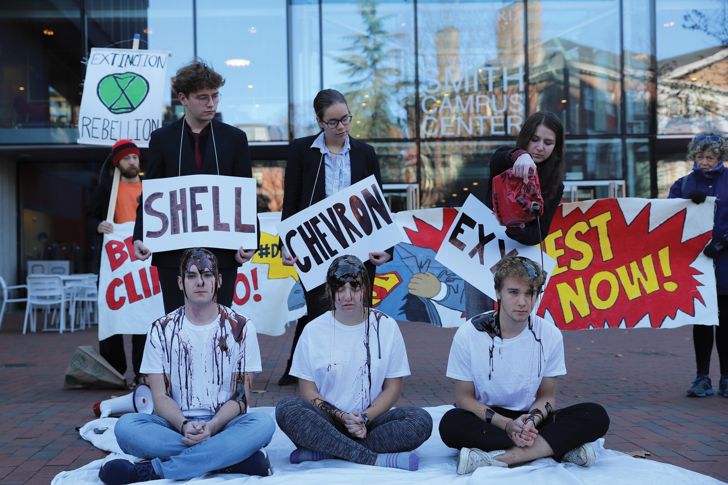 Protesters with the Harvard Divest movement staged a protest, in which they poured molasses — to represent oil — in front of the Smith Campus Center on Friday.