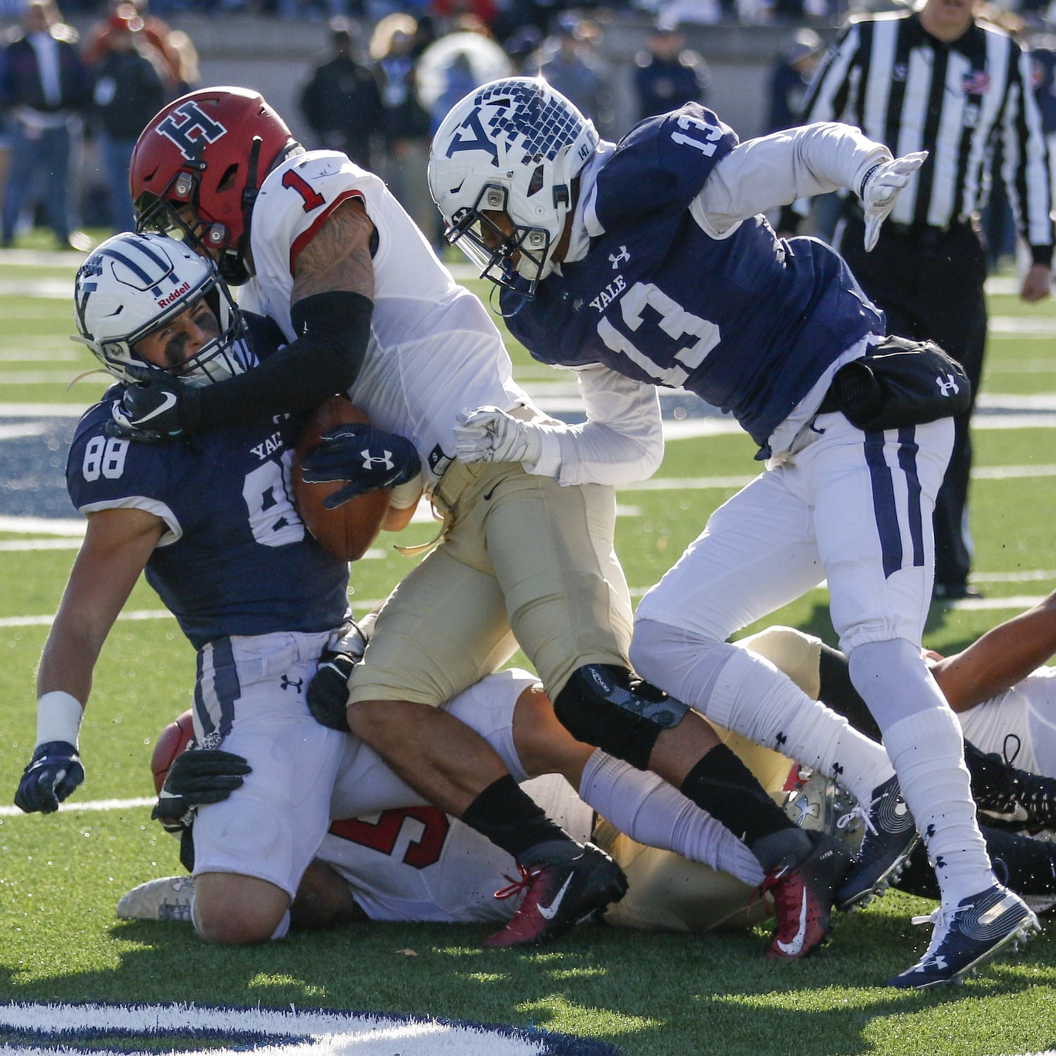 Harvard captain Wes Ogsbury tackles Yale captain JP Shohfi early in Saturday's contest. Both schools continue the tradition of selecting only a single captain, a rarity among collegiate football teams.