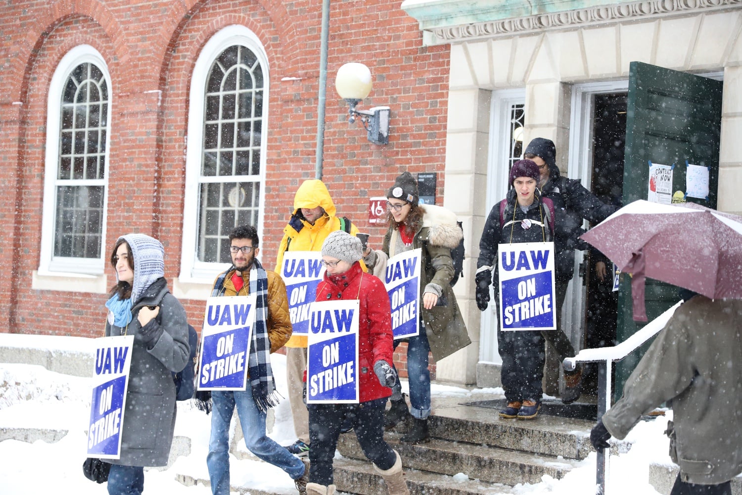 Members of Harvard's graduate student union stream out of Phillips Brook House, which is serving as "strike headquarters" to start picketing in Harvard Yard.