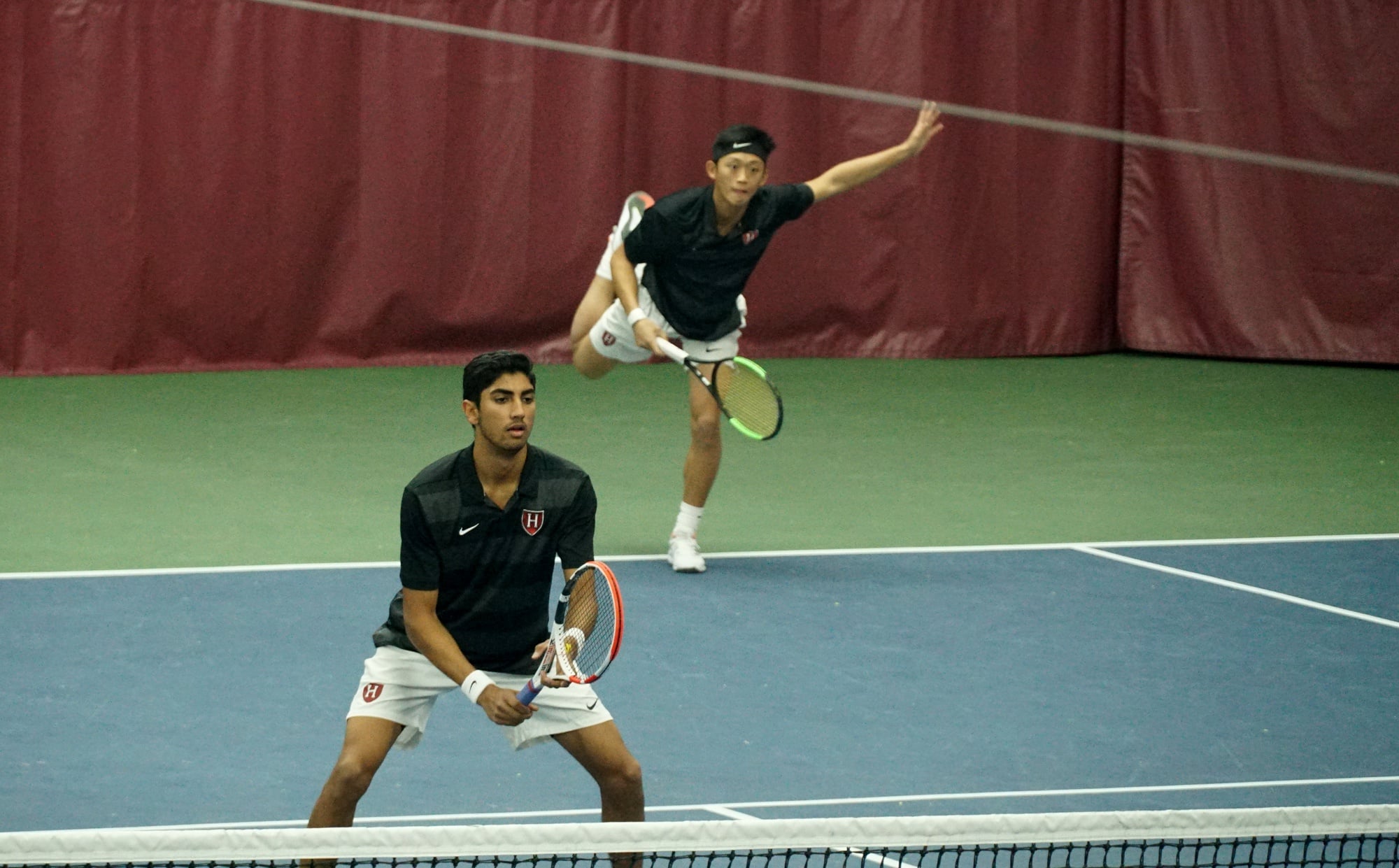 First-year Ronan Jachuk (front) awaits the opponent’s return as sophomore Brian Shi (back) delivers a serve in the Harvard victory over Rice. Combined with the women’s team, Crimson tennis would go a perfect 3-0 on the weekend.