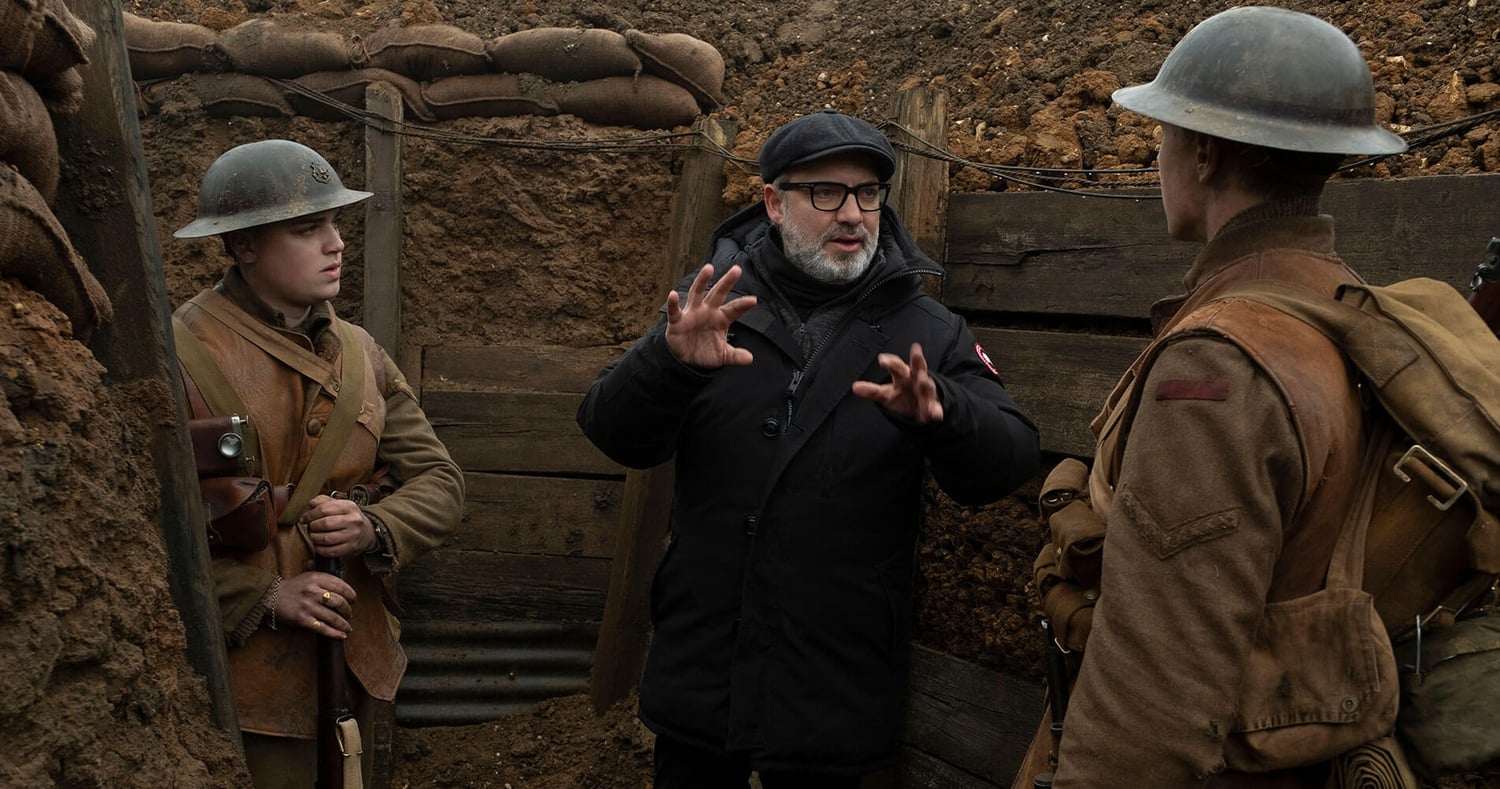 Sam Mendes (center) directs Dean-Charles Chapman (left) as Lance Corporal Thomas Blake and George MacKay (right) as Lance Corporal William Schofield in "1917" (2019).