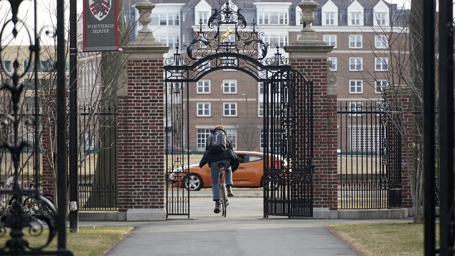 A student bikes through the gate connecting Winthrop House to Memorial Drive on a cool Wednesday afternoon.