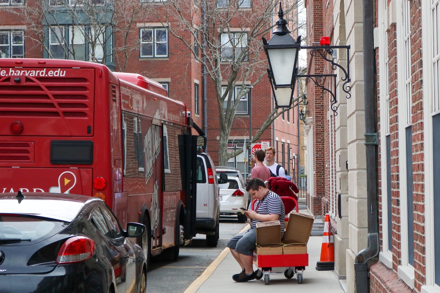 A student waits with his belongings outside of Leverett House in March 2020 after Harvard ordered all students to vacate campus.