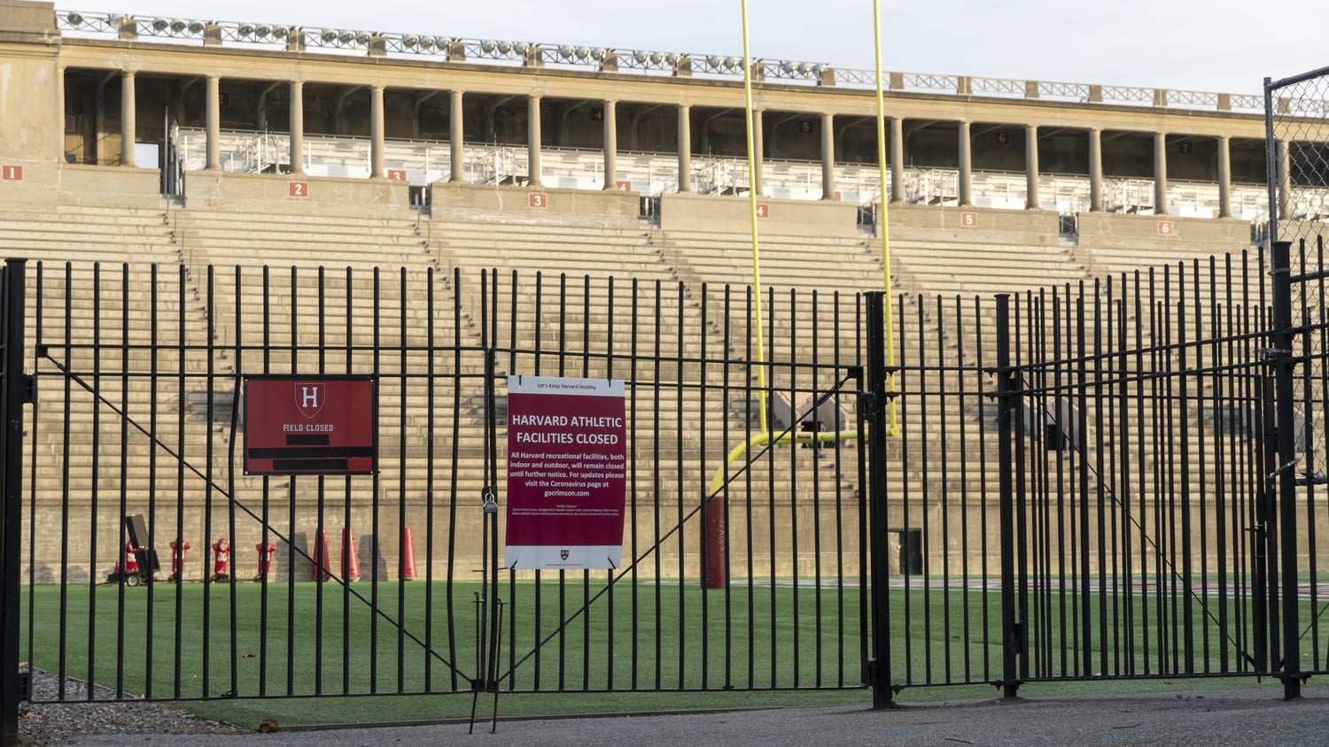 Signs posted outside Harvard Stadium announce that all recreational facilities are closed due to the COVID-19 pandemic.